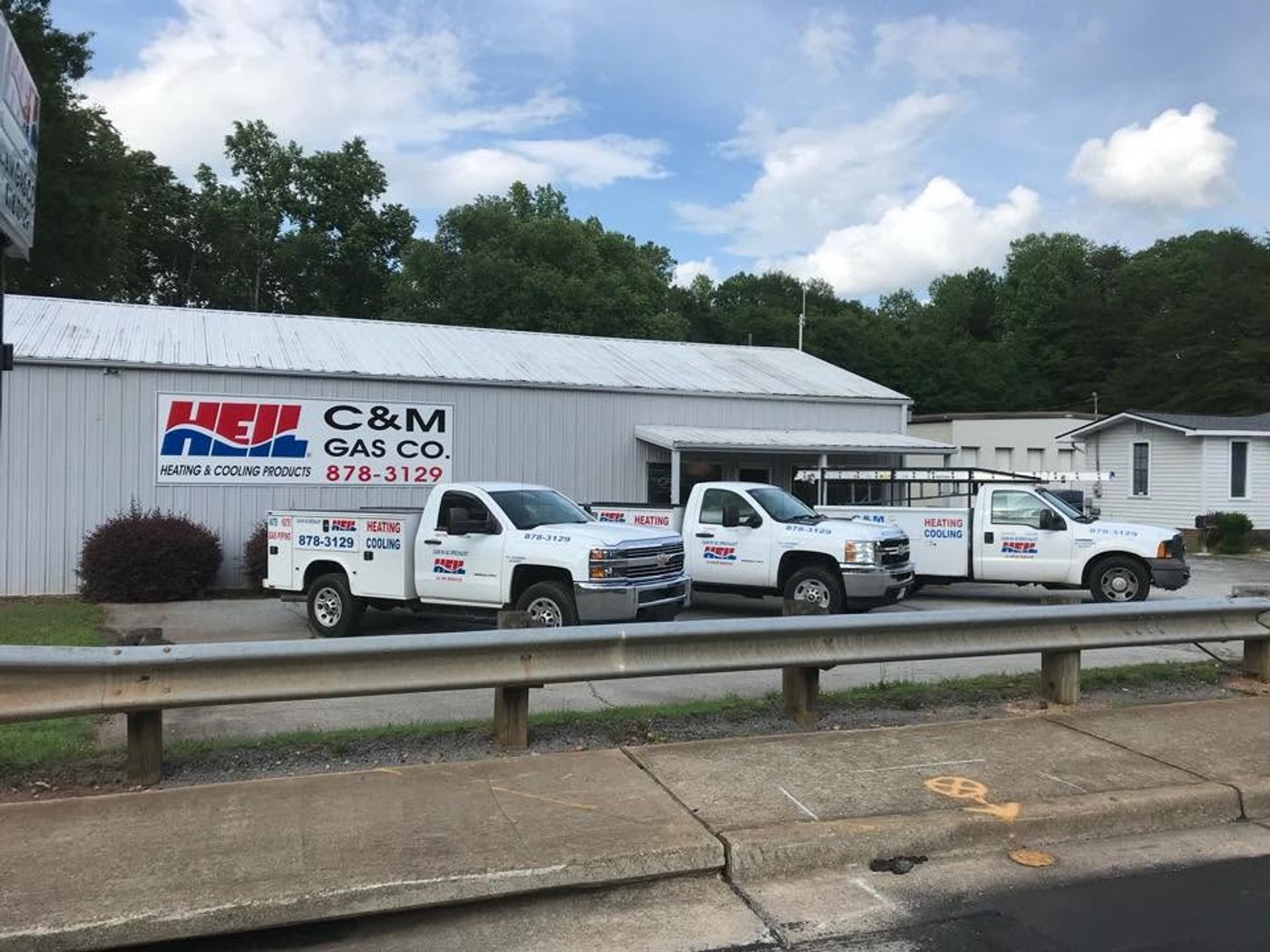Three C&M Gas Co. service trucks parked outside the company's warehouse.