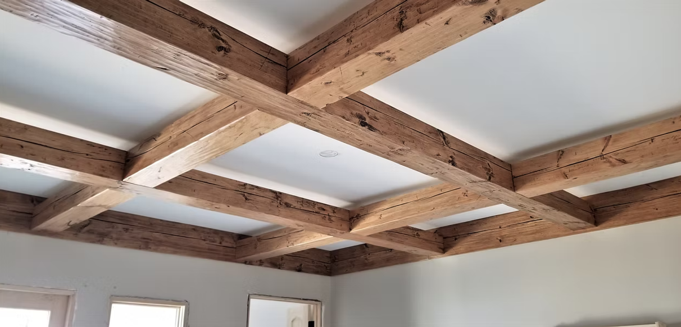 A coffered ceiling framed with reclaimed timber beams.