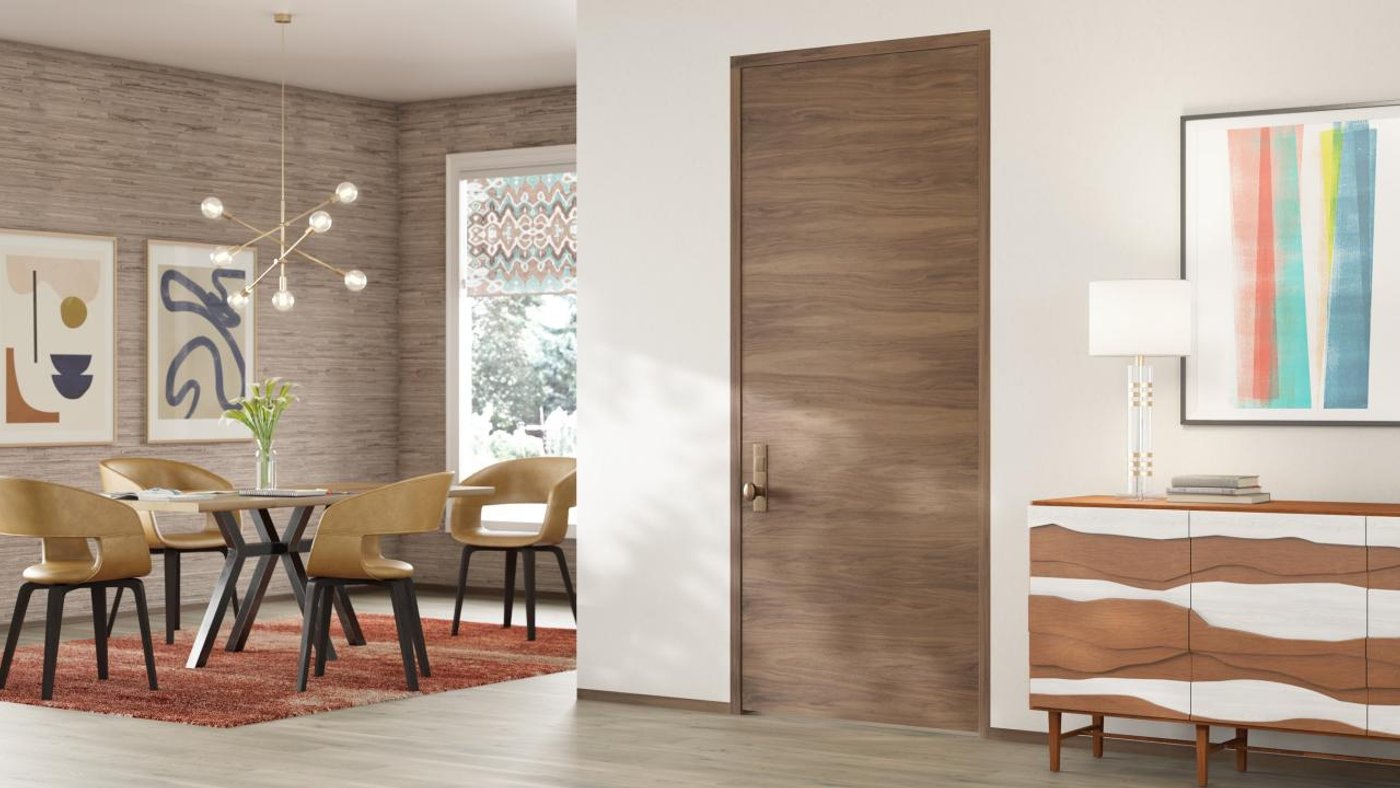 A flush walnut interior door in a modern room with a dining area and sideboard.