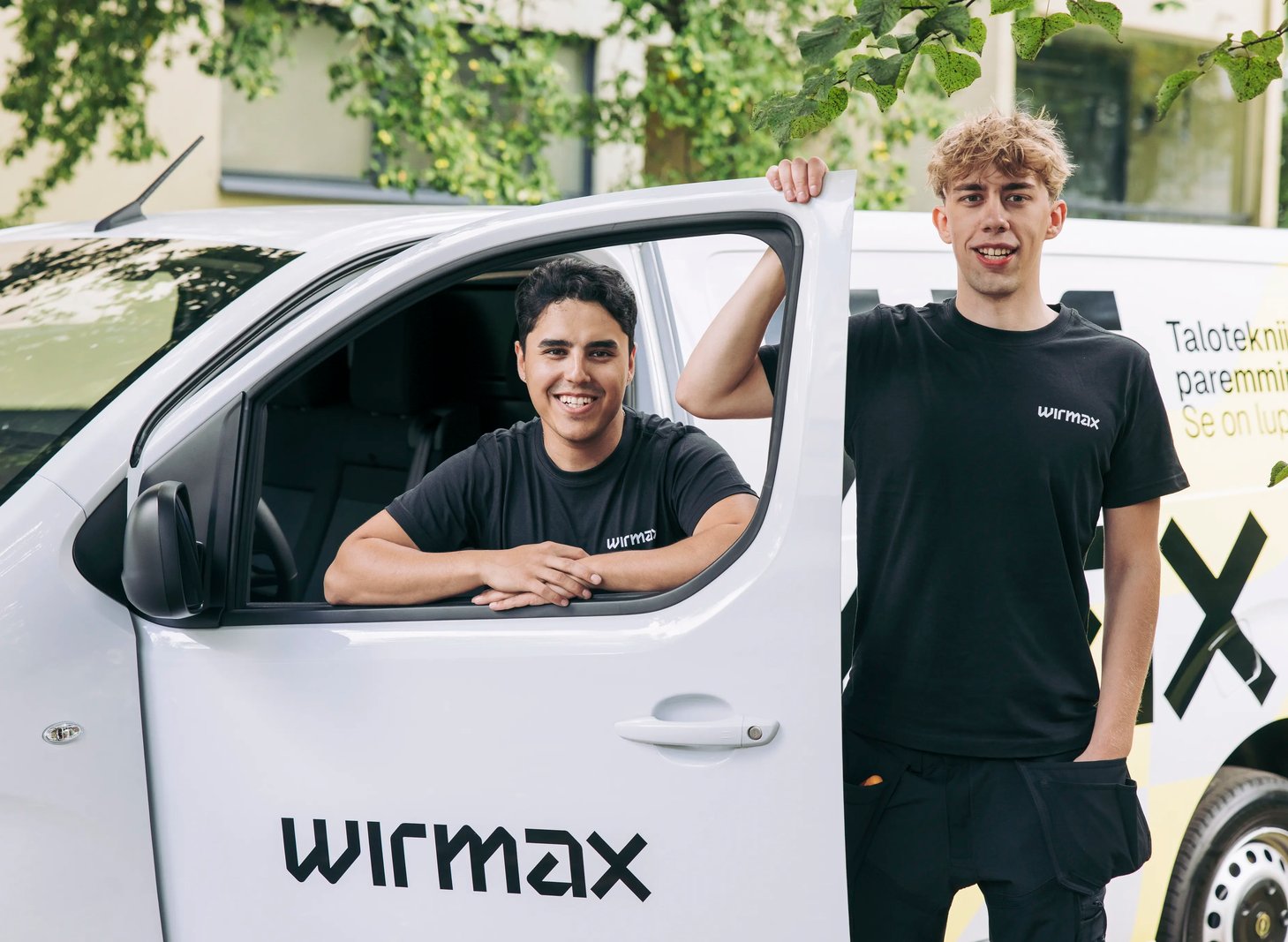 A Wirmax electrician and plumber standing in front of a service van
