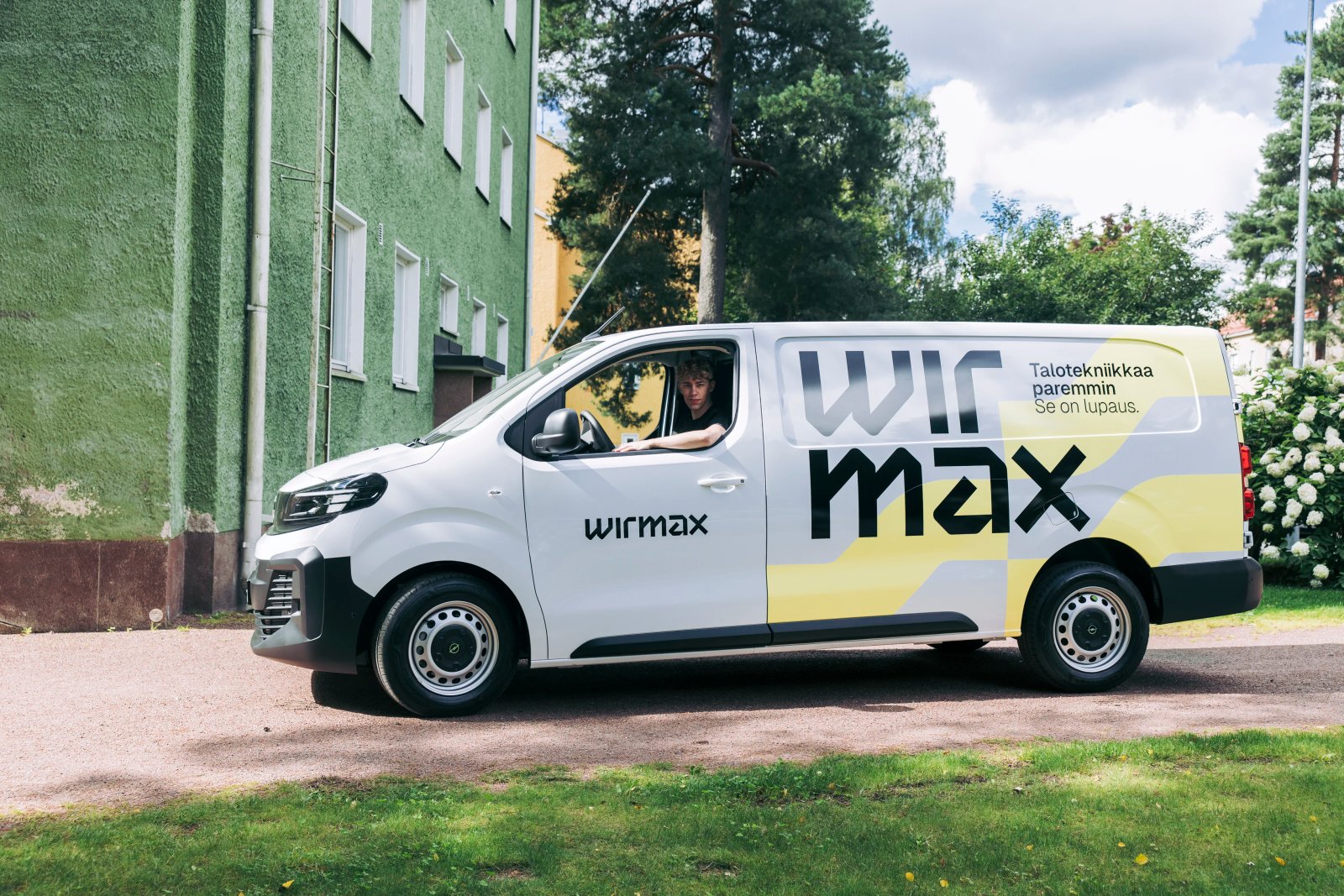 Wirmaxin asentaja näyttää tablettia työkaverilleen pakettiauton vierellä.