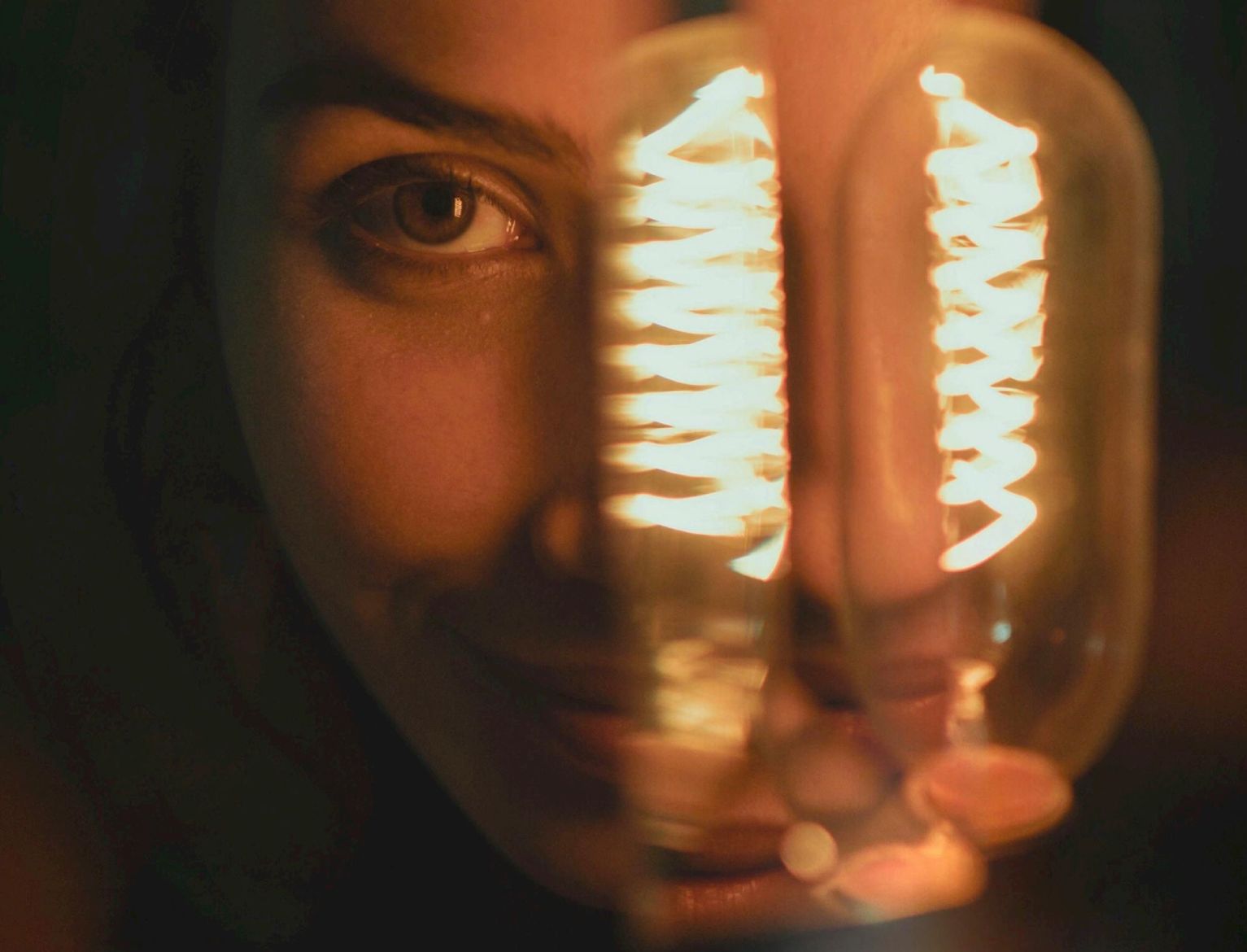 il volto di una persona illuminato da una lampadina