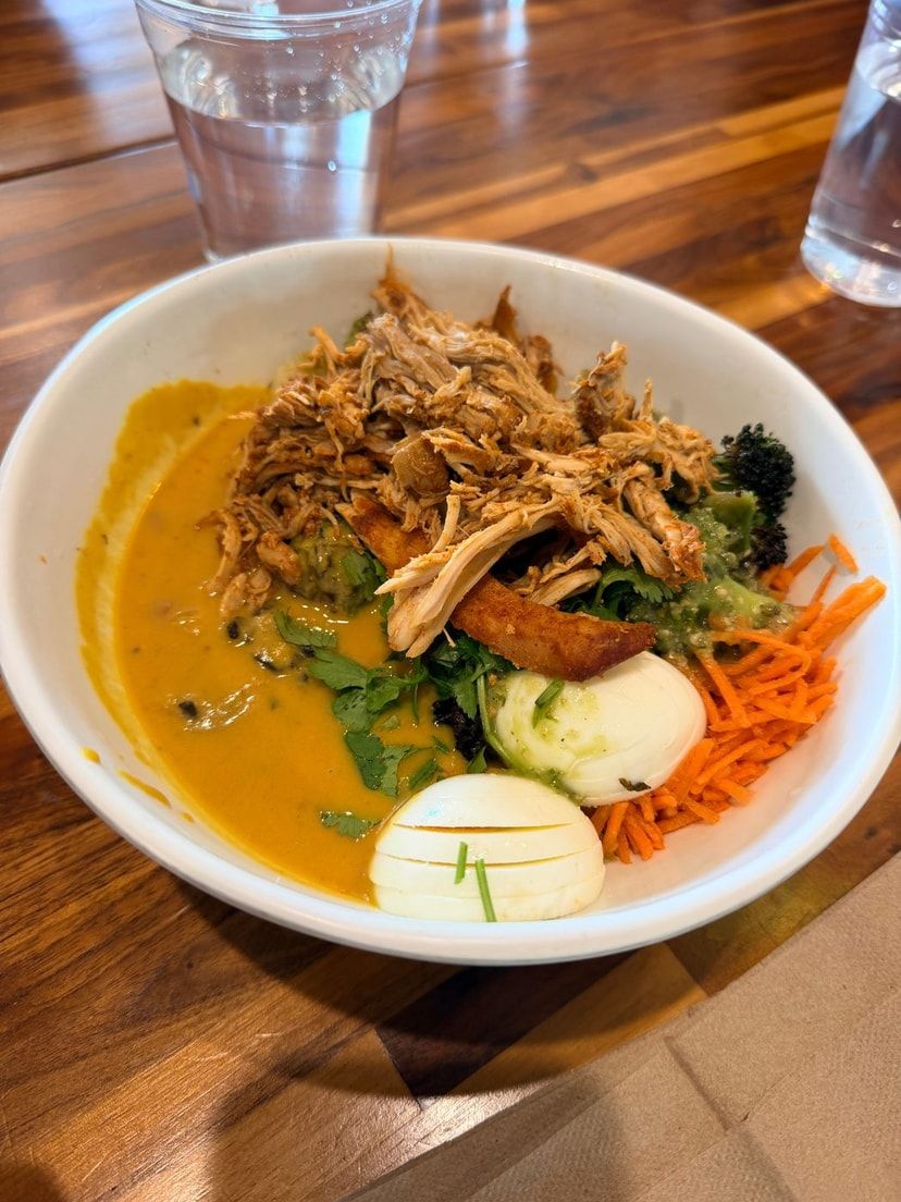 A warm bowl of soup topped with vegetables