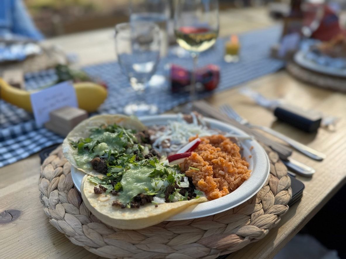 A plate of greens and roasted vegetables on a laid table