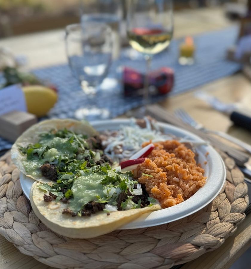 A plate of greens and roasted vegetables on a laid table