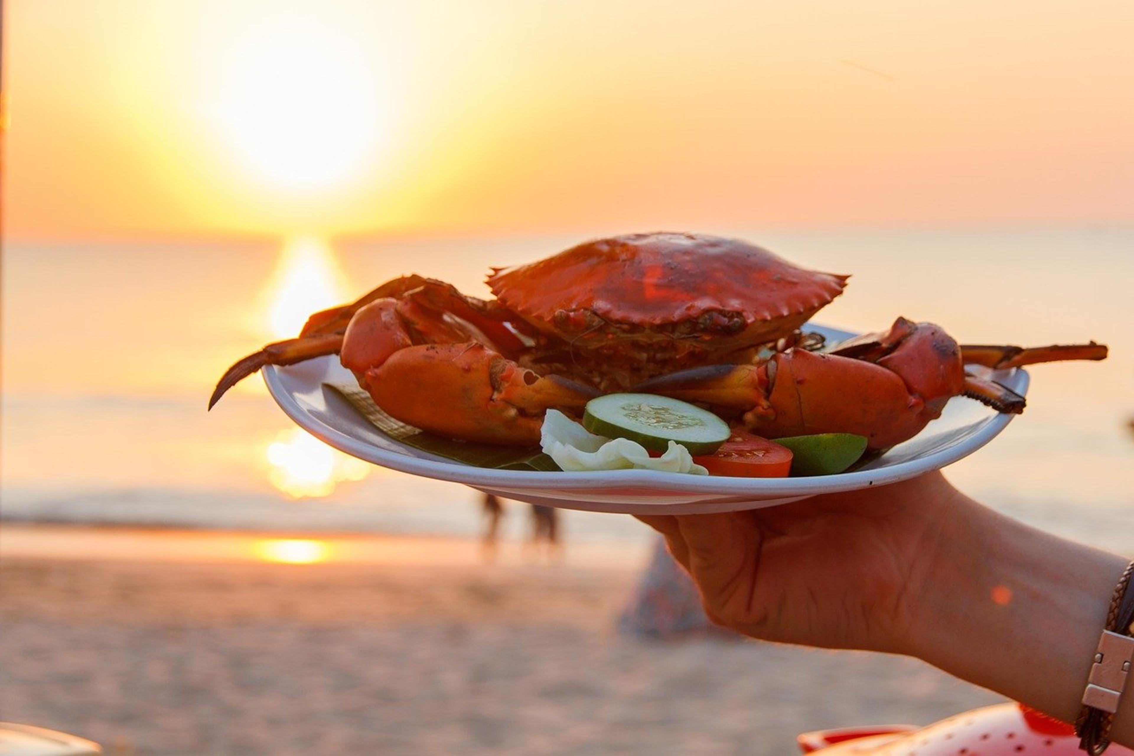 Tasting crab dish at the seaside during sunset