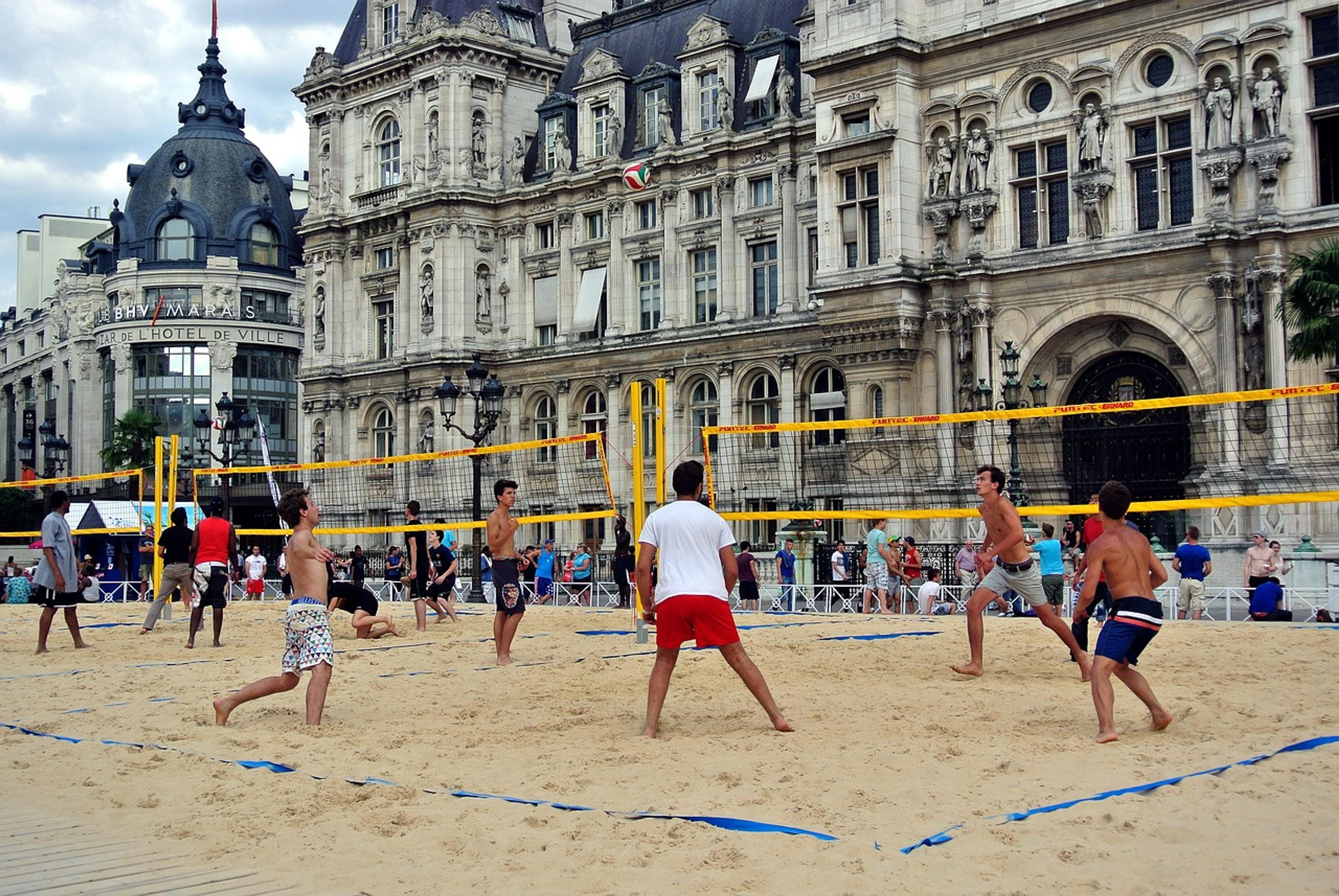 Young men are playin beach volleyball in Paris