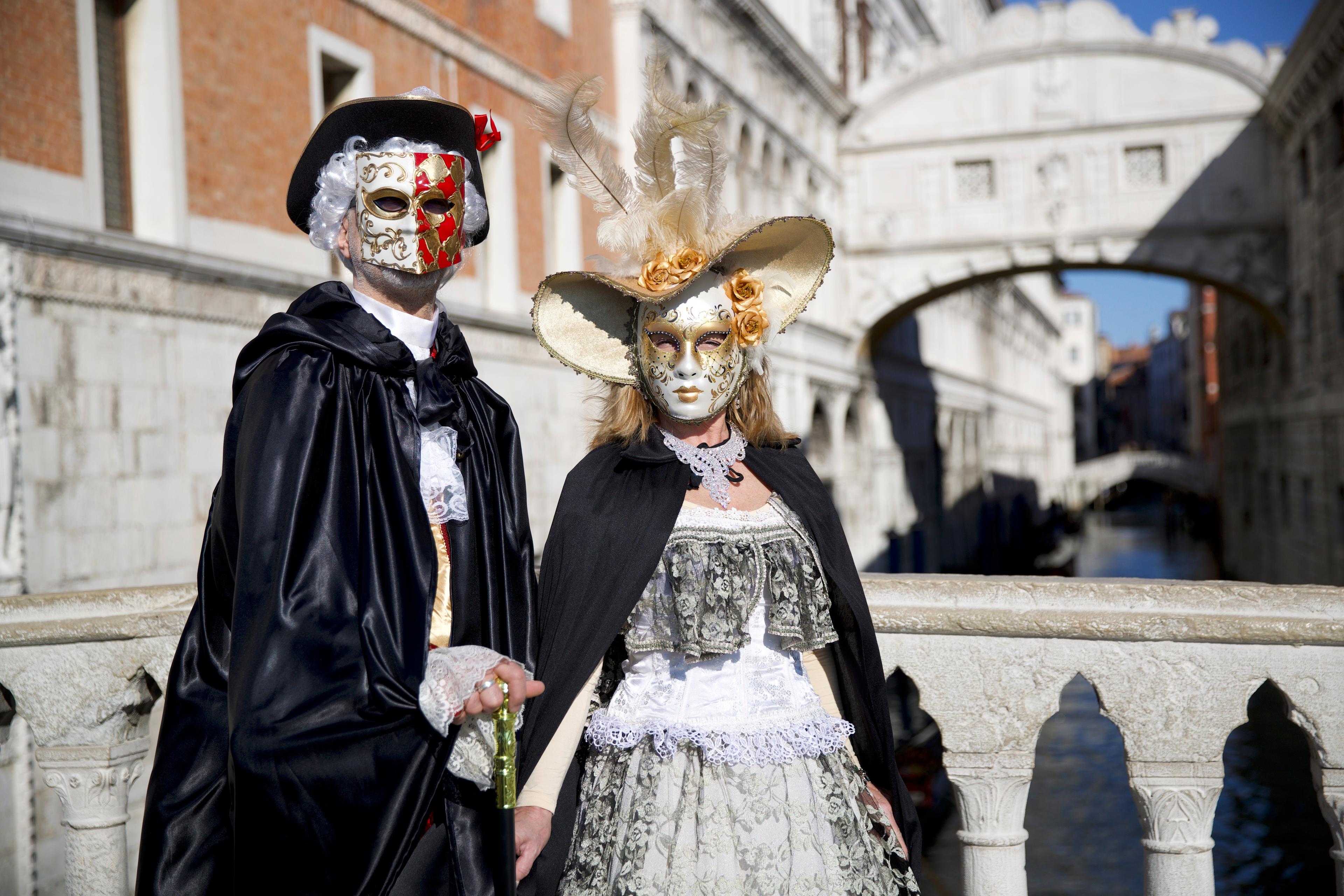 ein Paar mit Masken auf der Brücke in Venedig während der Karnevalstage