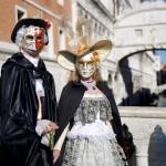 ein Paar mit Masken auf der Brücke in Venedig während der Karnevalstage
