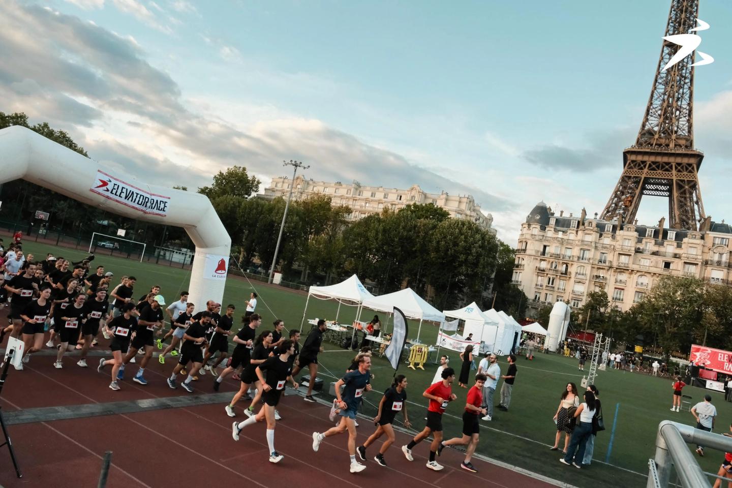 Photo du départ de l'Elevator Race by Theop Group : coureurs sur la piste, tour Eiffel en arrière-plan, Paris