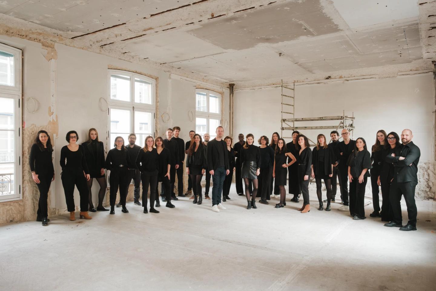 Photo de groupe de l'équipe PDA Architecture réunie dans un grand plateau lumineux de l'agence, Paris