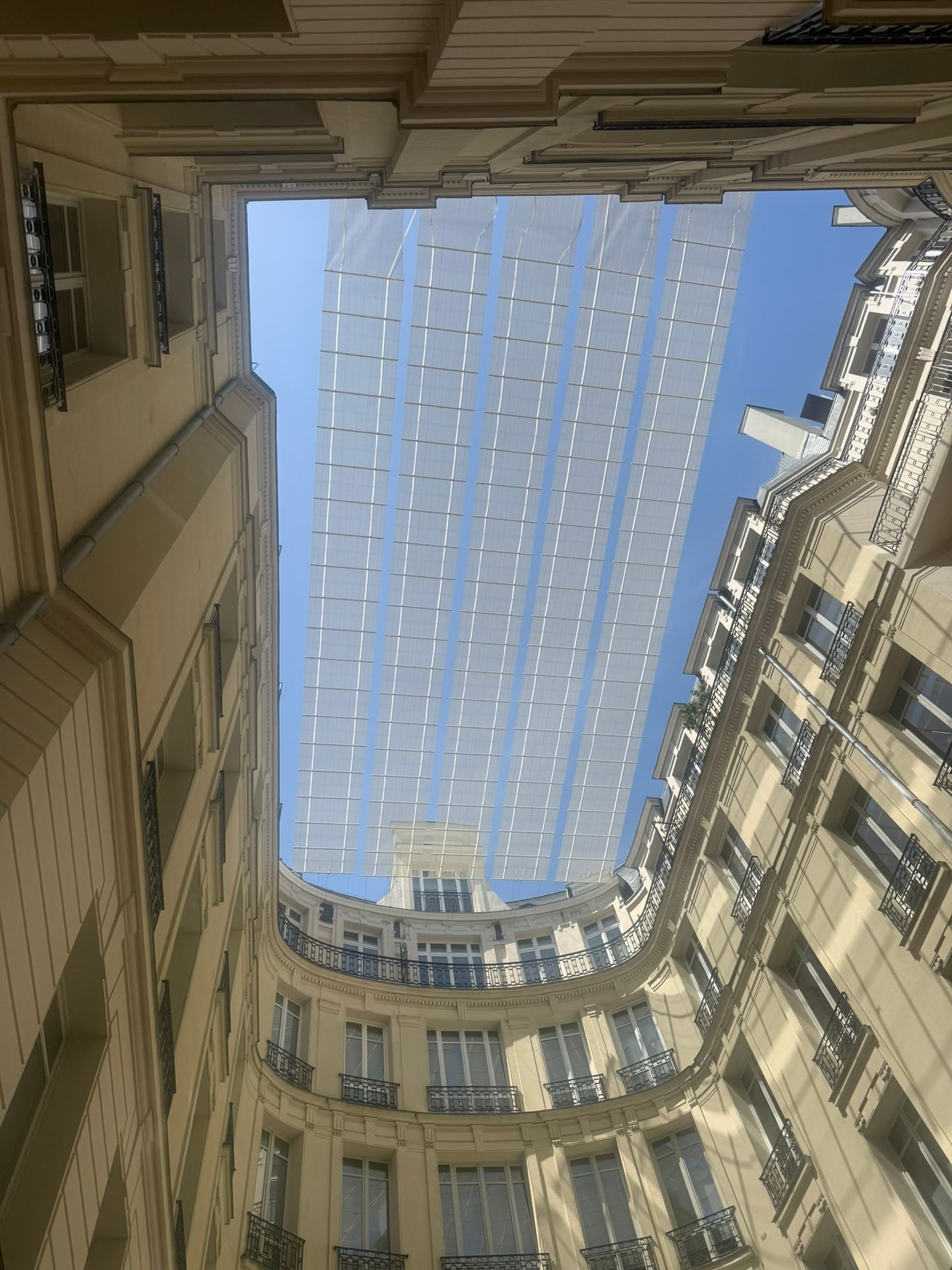 Photo en contre-plongée de la canopée bioclimatique de Virtuose fermant la cour intérieure, Paris 16