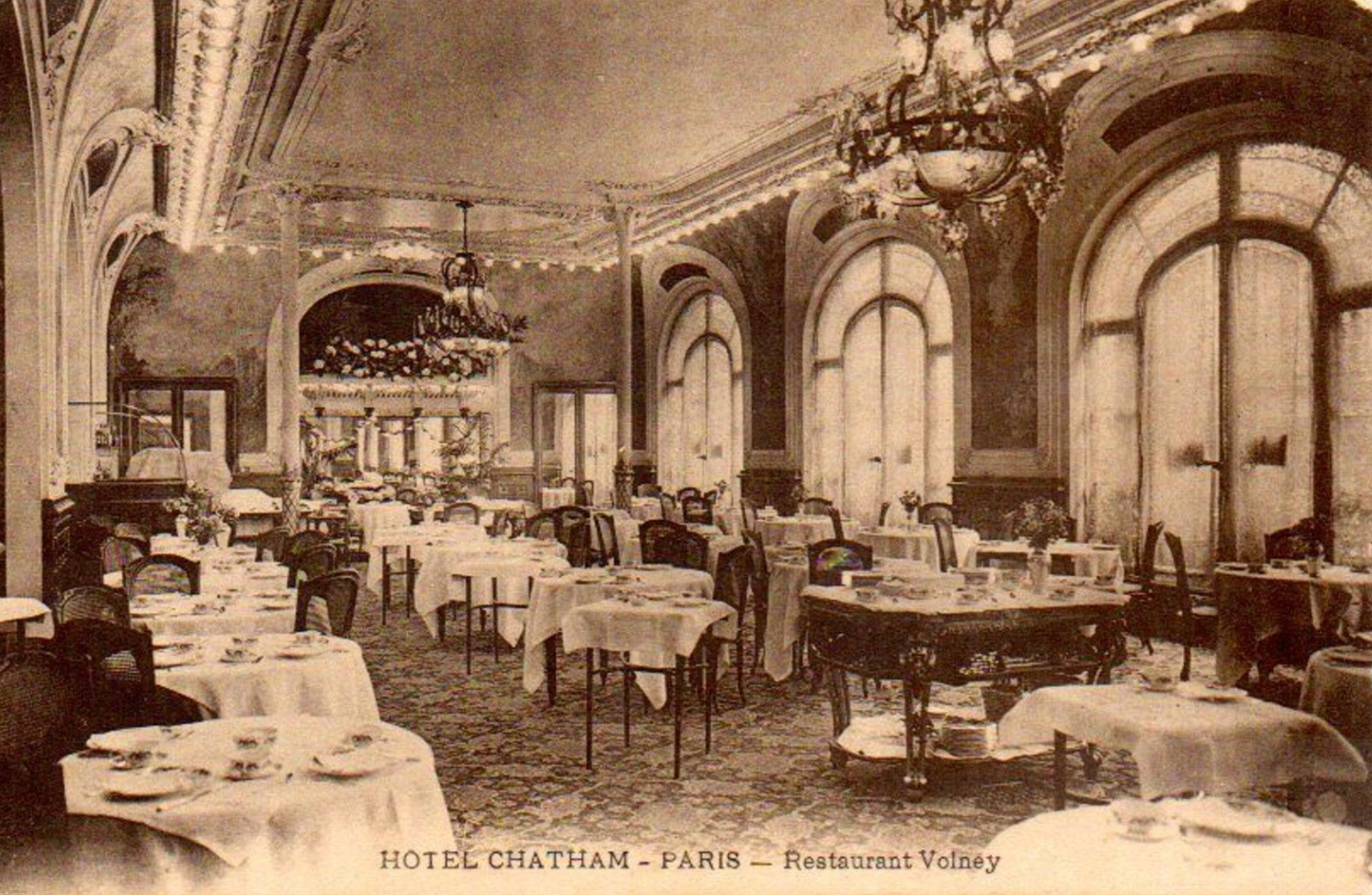 Carte postale ancienne du restaurant de l'Hôtel Chatham, rue Volney : salle à lustres et tables dressées, Paris 1