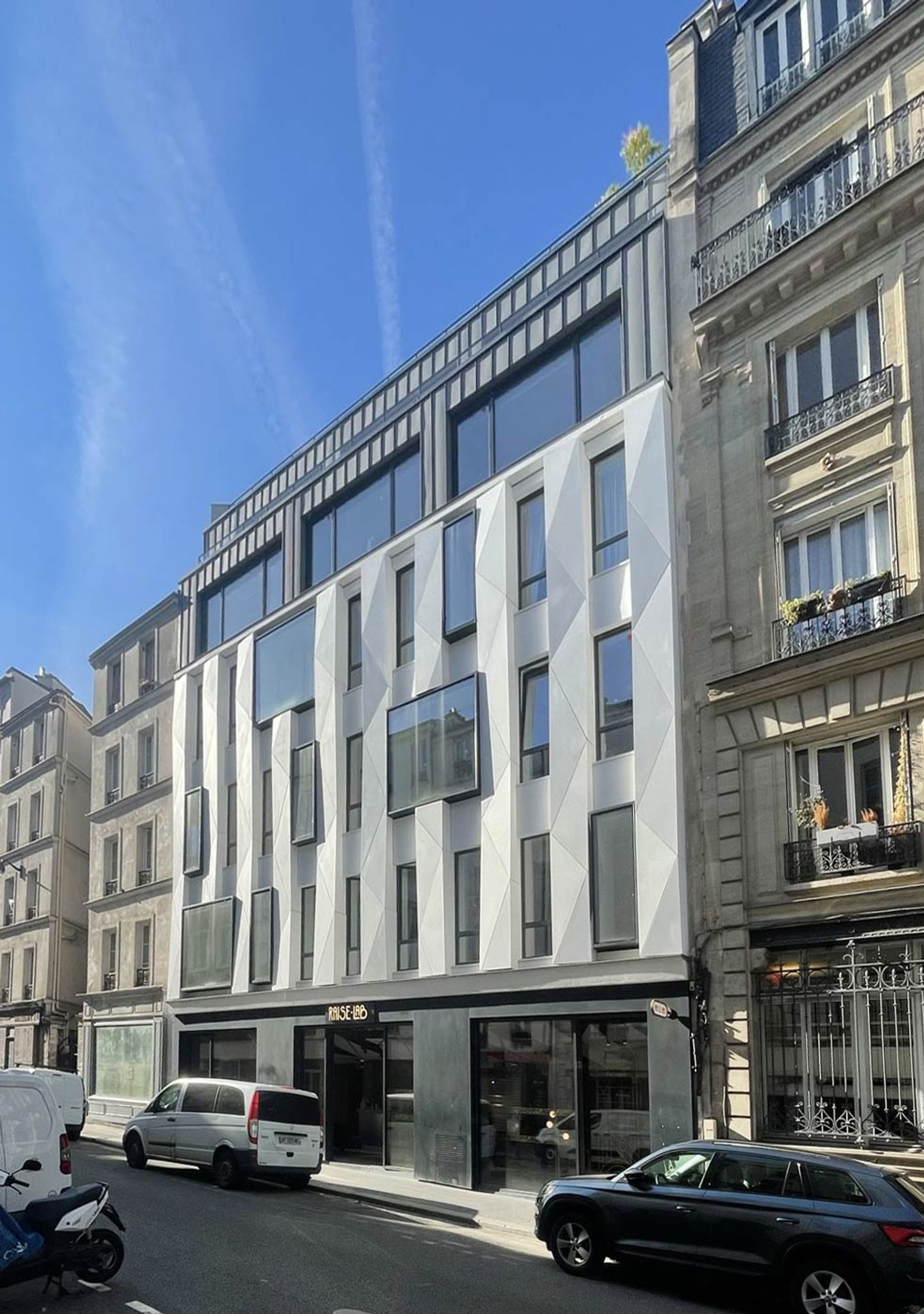 Photo of the white RaiseLab facade on rue de la Fontaine-au-Roi, between two Parisian buildings, Paris 11th