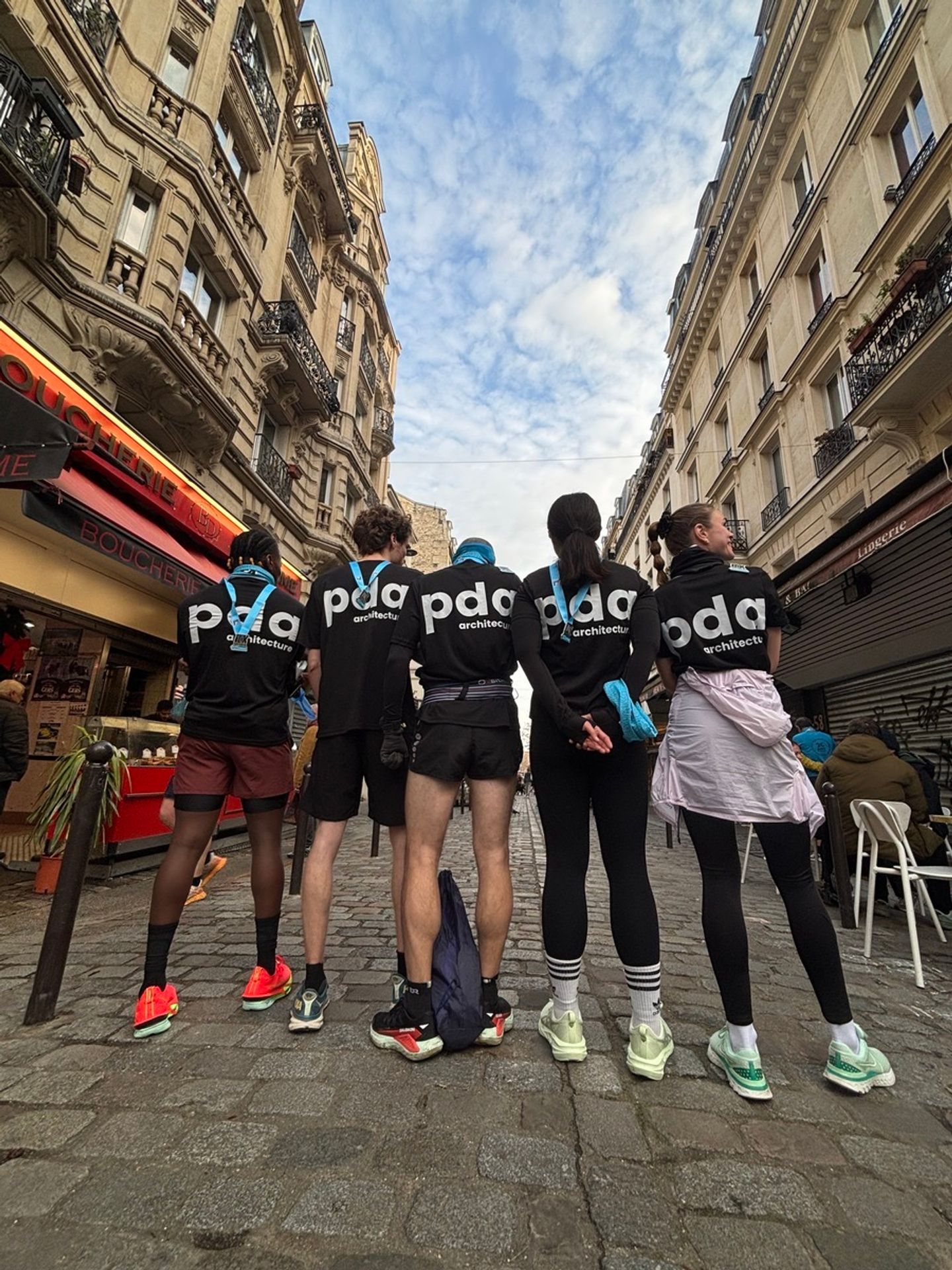 Photo de dos de coureurs de PDA Architecture en t-shirts noirs siglés pda, 10K Montmartre, Paris 18