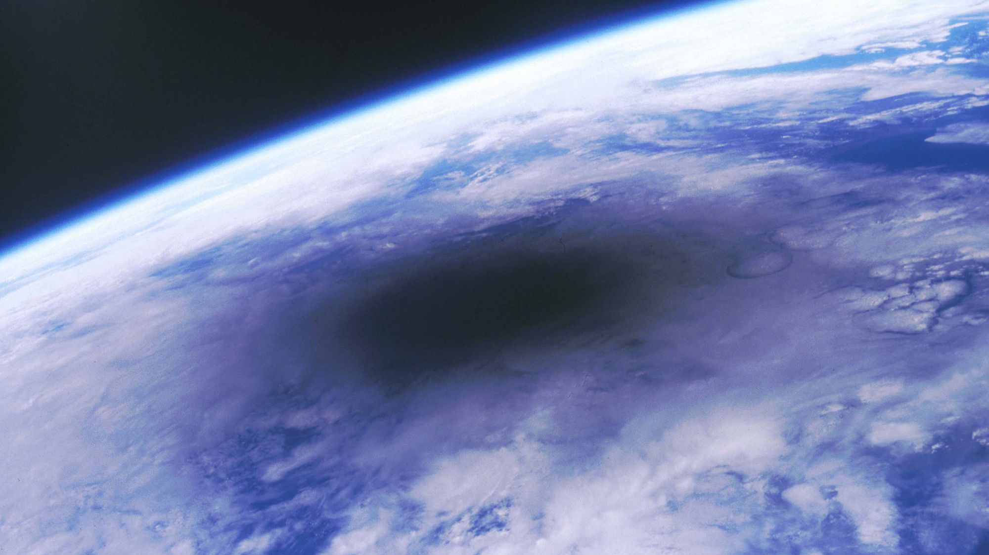 A partial view of the curve of Earth from space during an eclipse