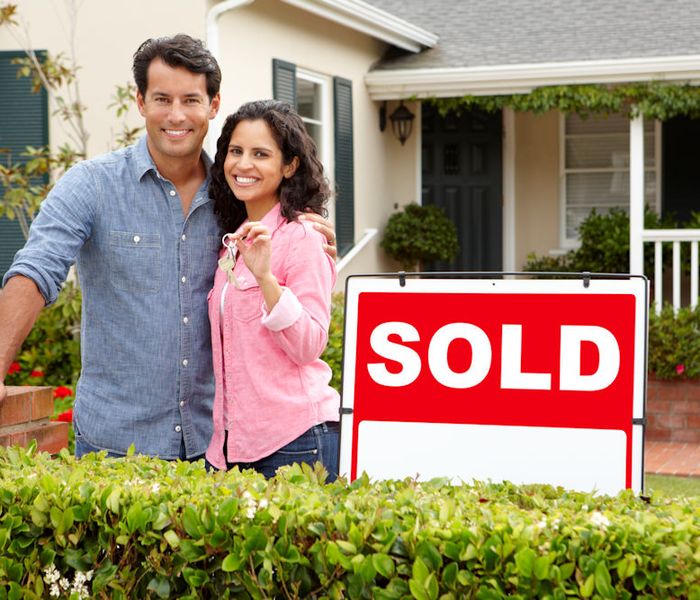 Couple in front of newly bought house using a VA Loan.
