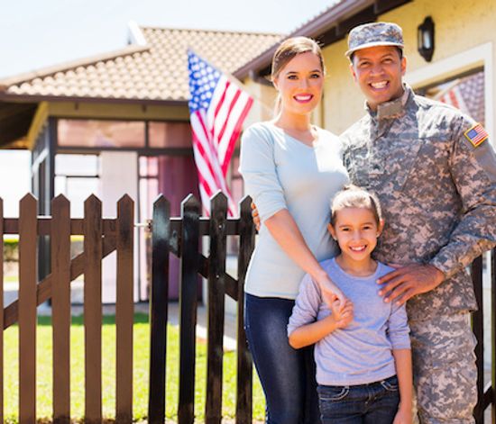 Military with his family standing in house acquired using a VA loan.