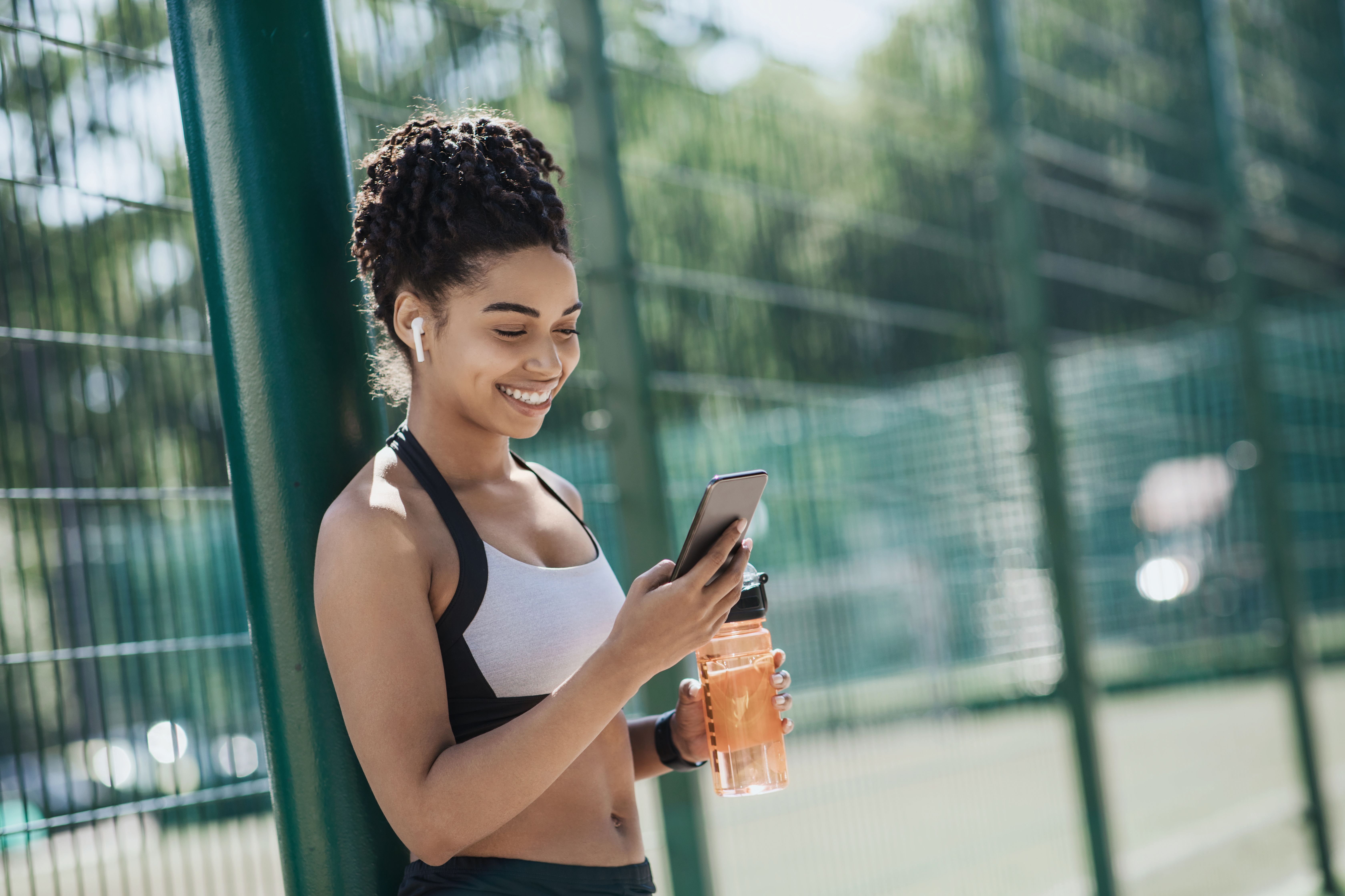 Inspired lady checking fitness app statistics feeling motivated