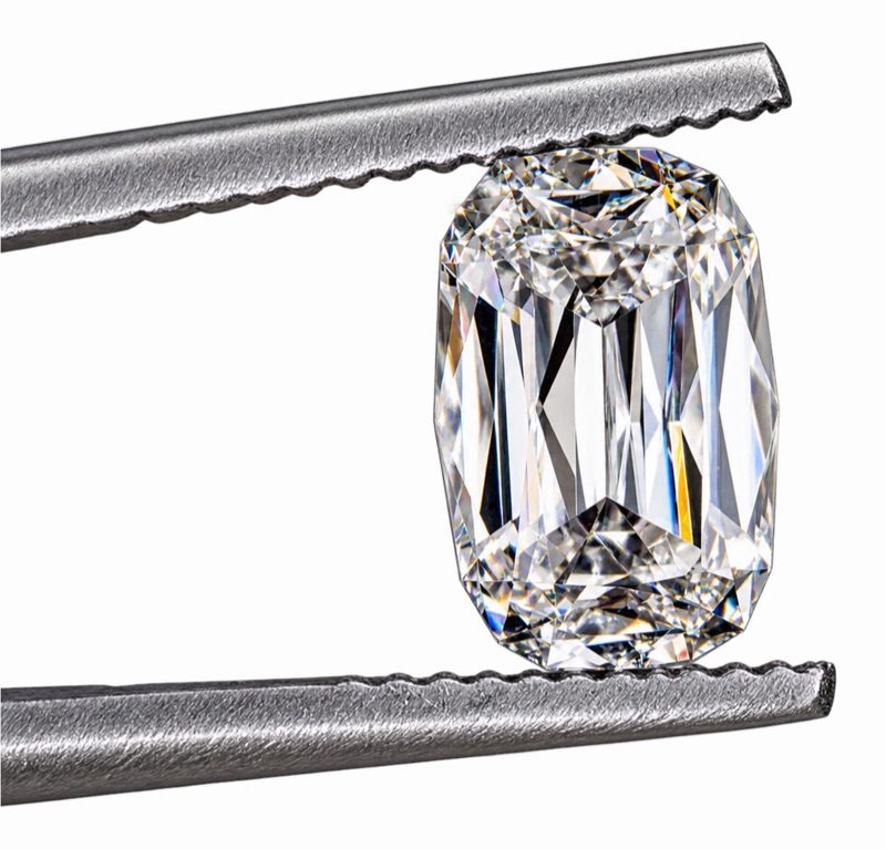 Un diamant taillé tenu par une pince de sertisseur