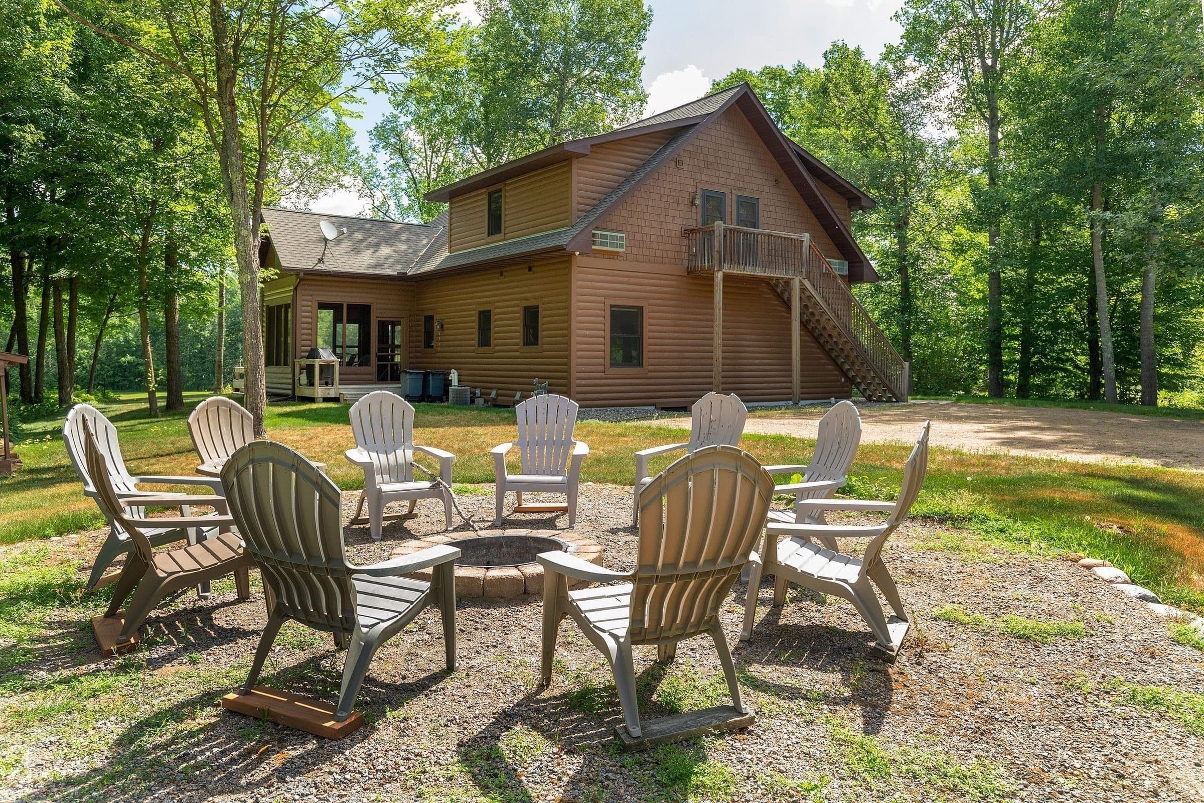 Adirondack chairs circling the outdoor fire pit behind The Cottage at Golden Eagle