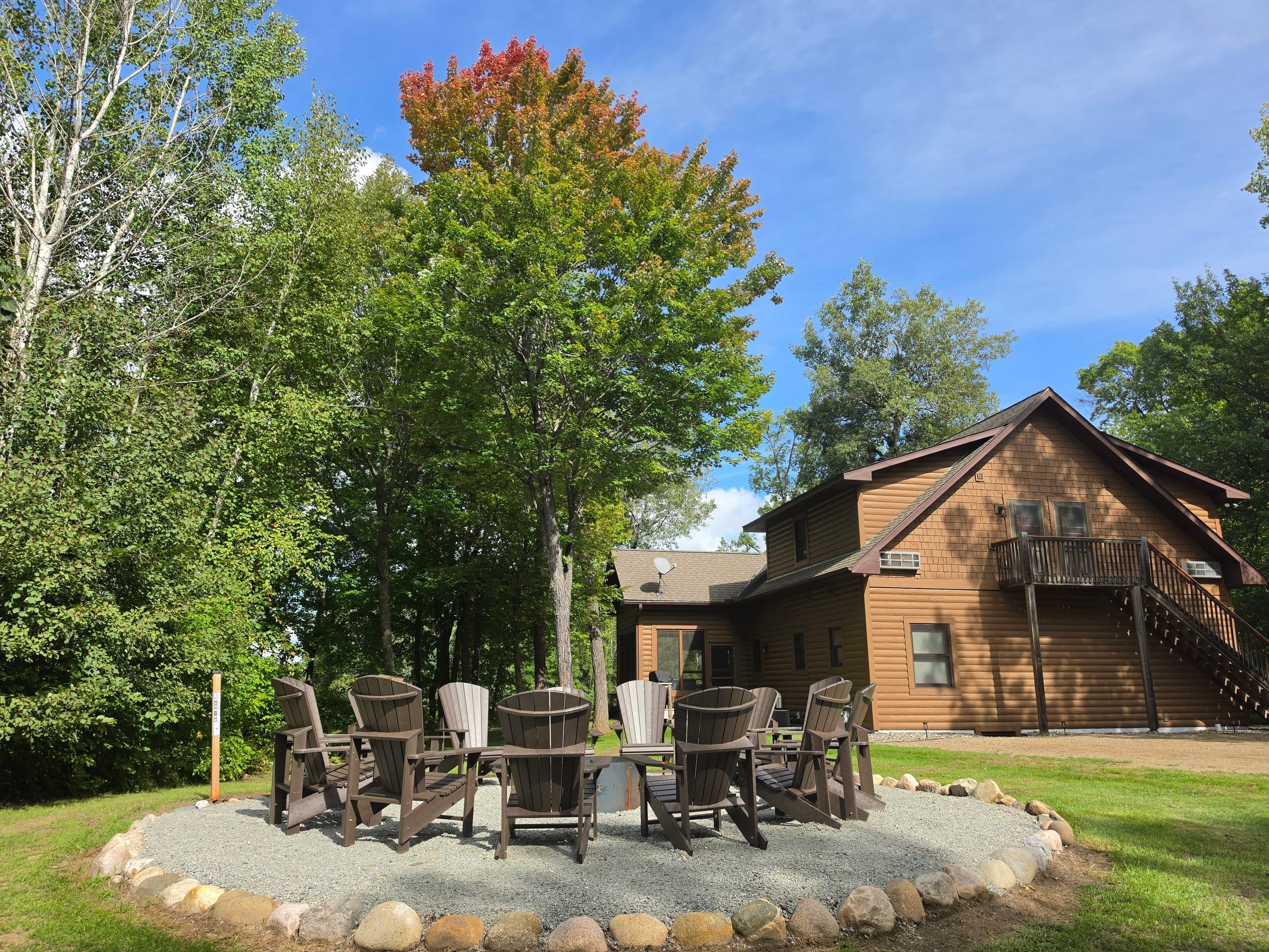 Adirondack chairs arranged around the fire pit outside The Cottage at Golden Eagle