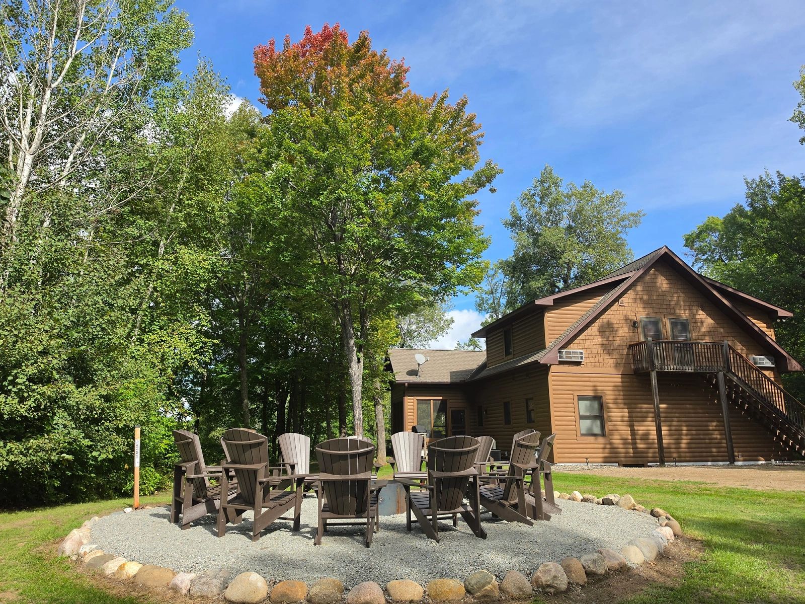 Adirondack chairs arranged around the fire pit outside The Cottage at Golden Eagle