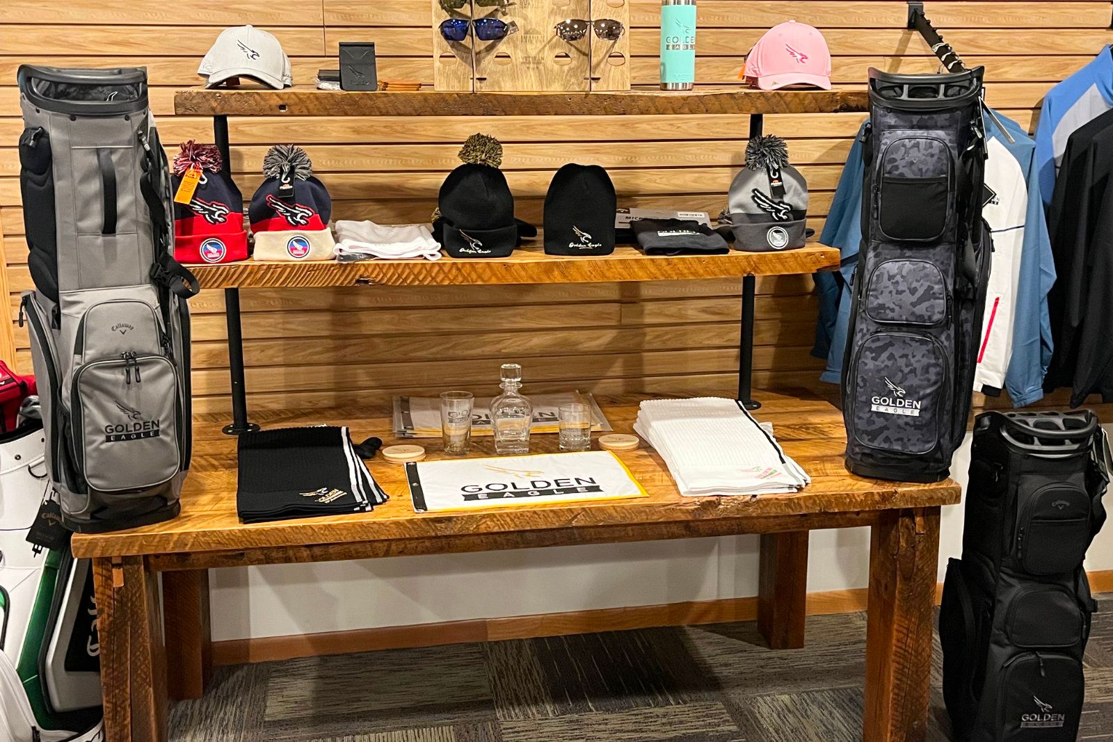 Golden Eagle beanies, hats, and a logo golf towel on display in the Pro Shop