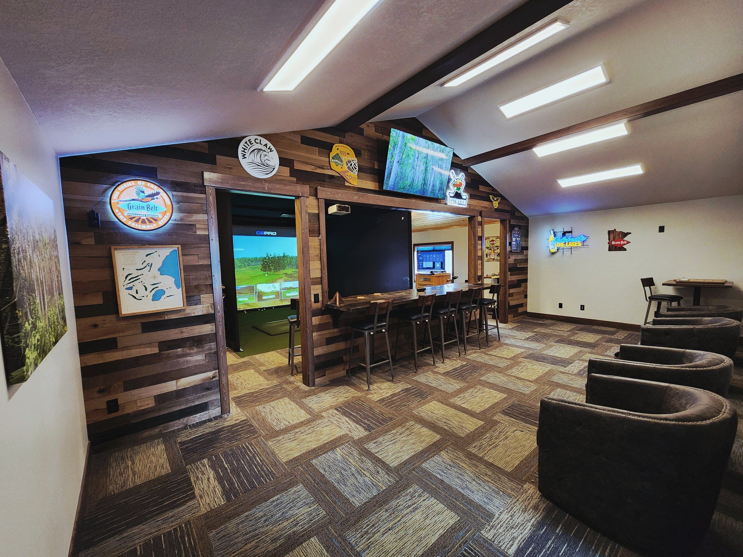 Golden Eagle’s golf simulator lounge with leather chairs and large screens