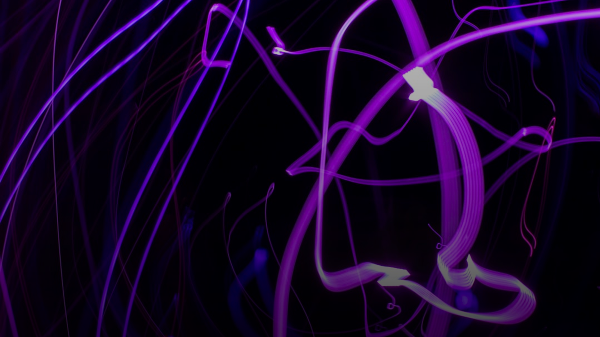 Abstract purple light trails on black background