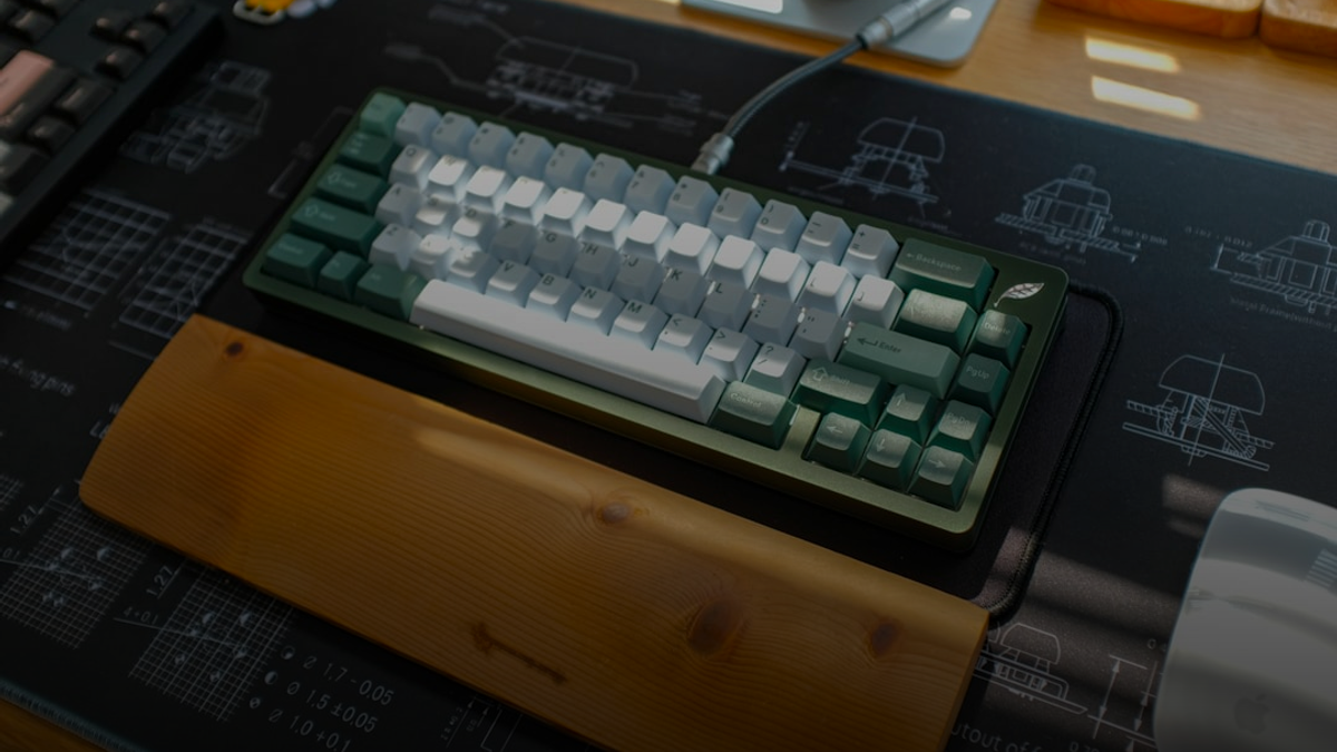 A mechanical keyboard sits on a desk mat.