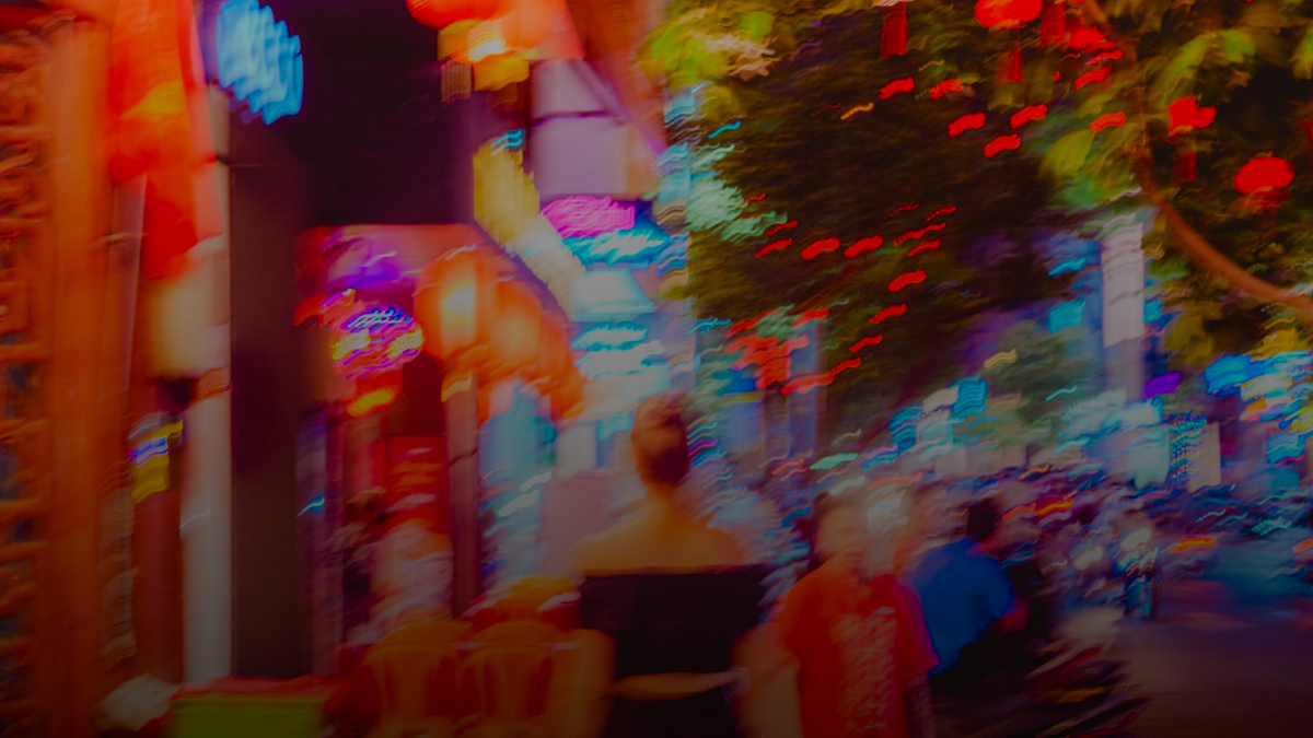 People walk along a street lined with decorations.