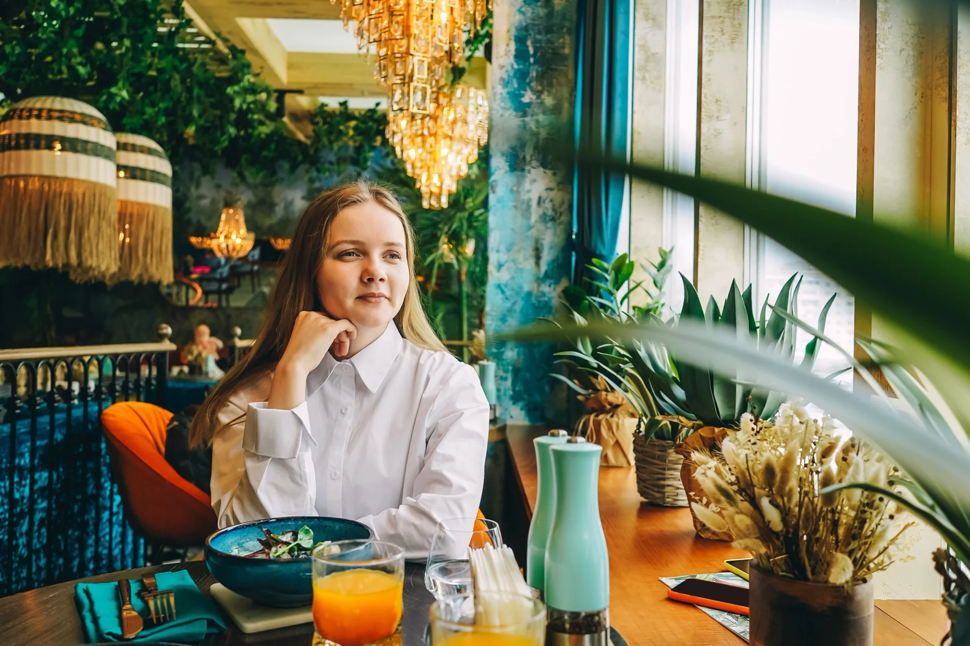 A woman enjoying a meal at a table, showcasing sustainable food options on a digital menu.