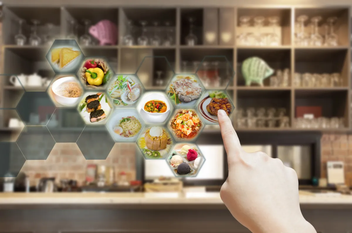 A hand touching a menu with delicious food on it - experience the convenience of digitizing your restaurant.