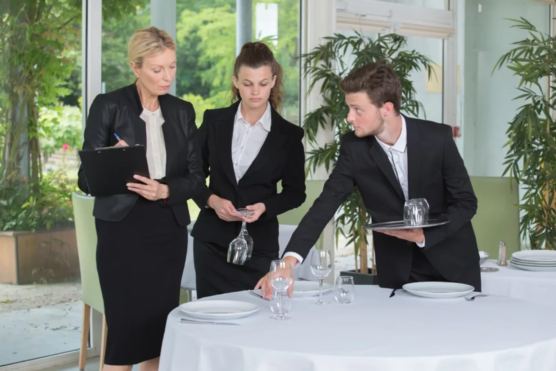 Three professionals in business attire discussing ideas around a table.