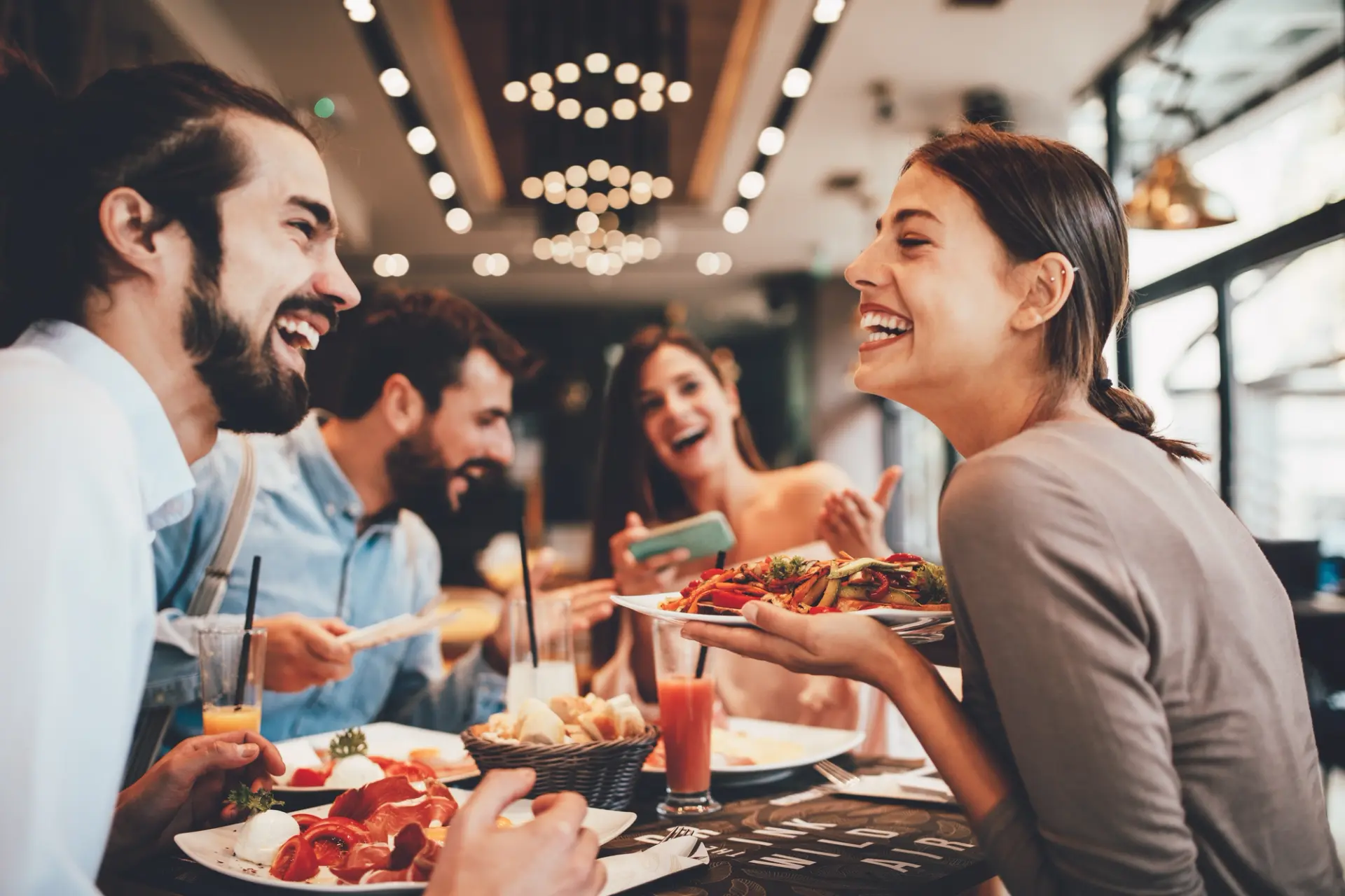 A diverse group of individuals enjoying a meal together at a restaurant.