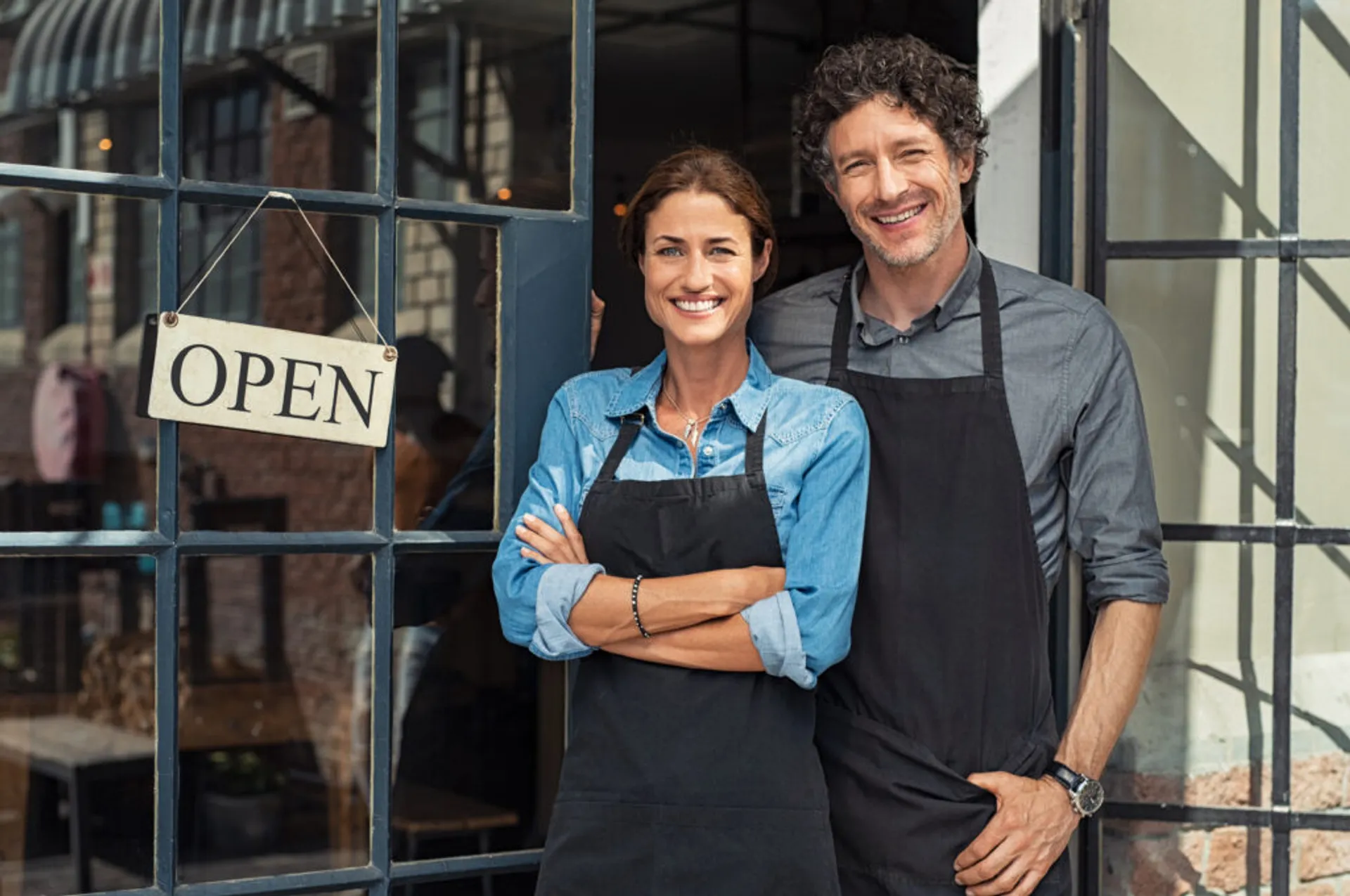A man and woman engaged in conversation outside a business discussing a restaurant business plan.