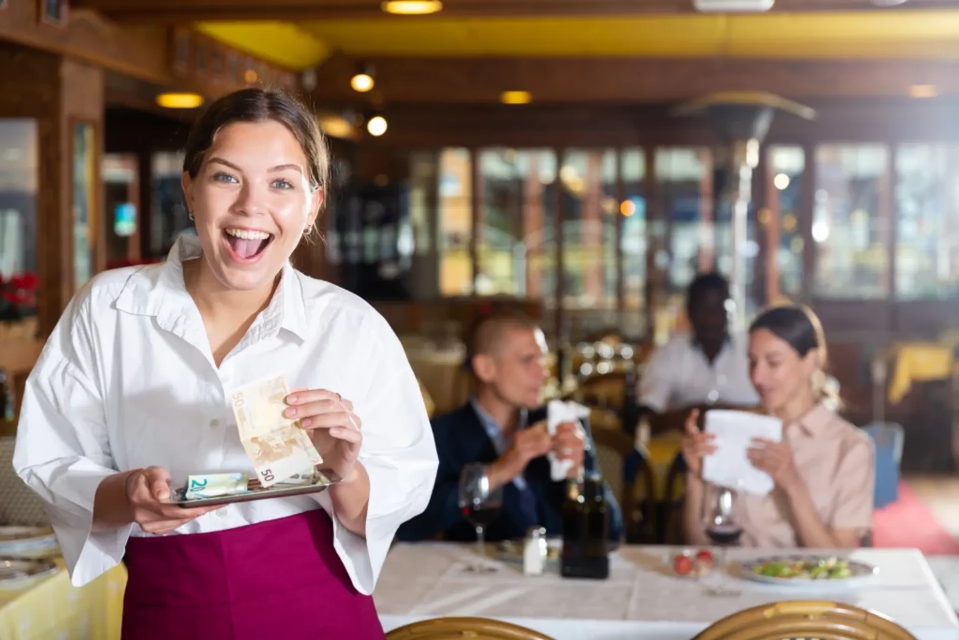 A woman in an apron holding a tip management.