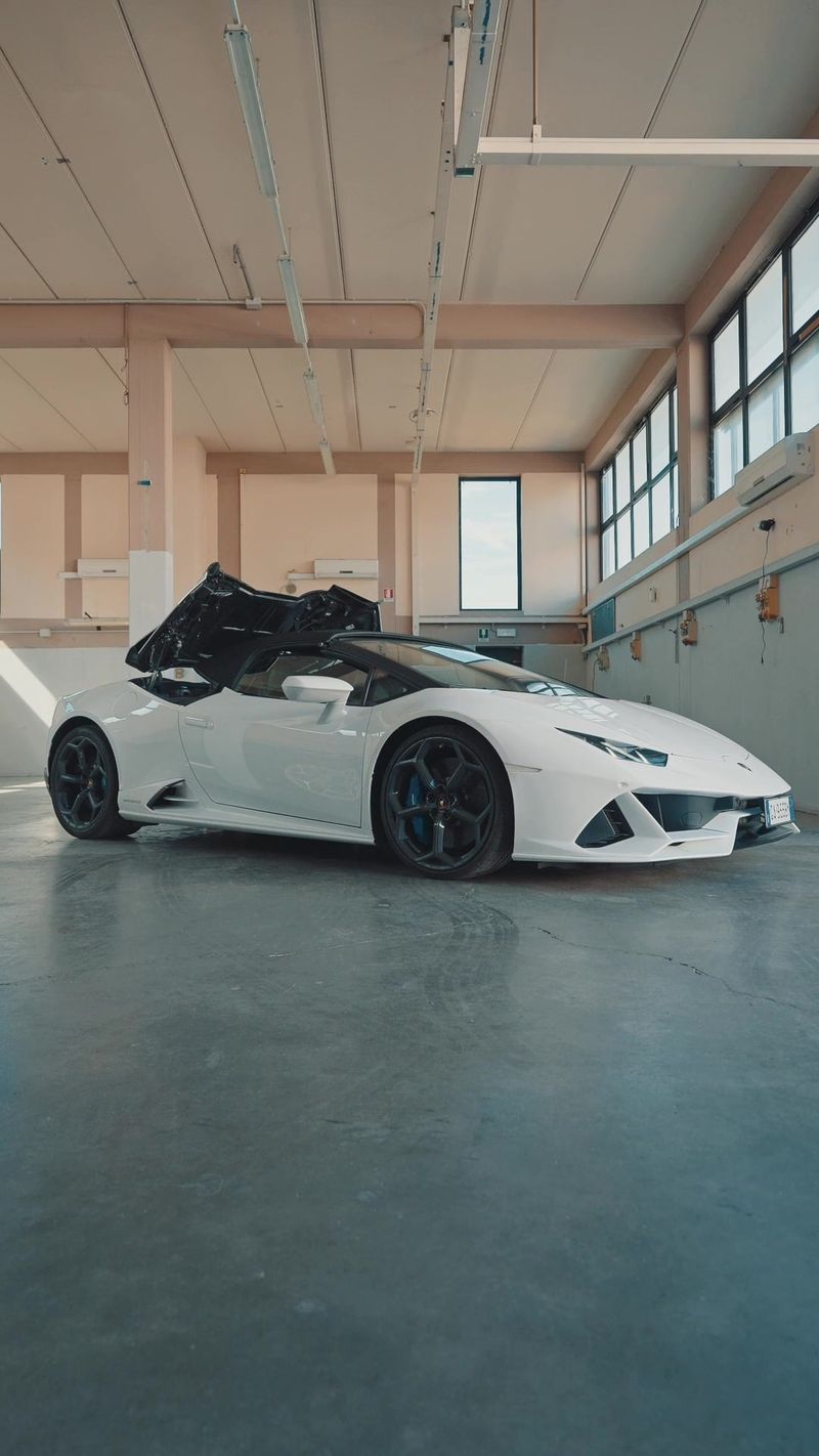 Una Lamborghini bianca ferma dentro a un capannone con le finestre alte