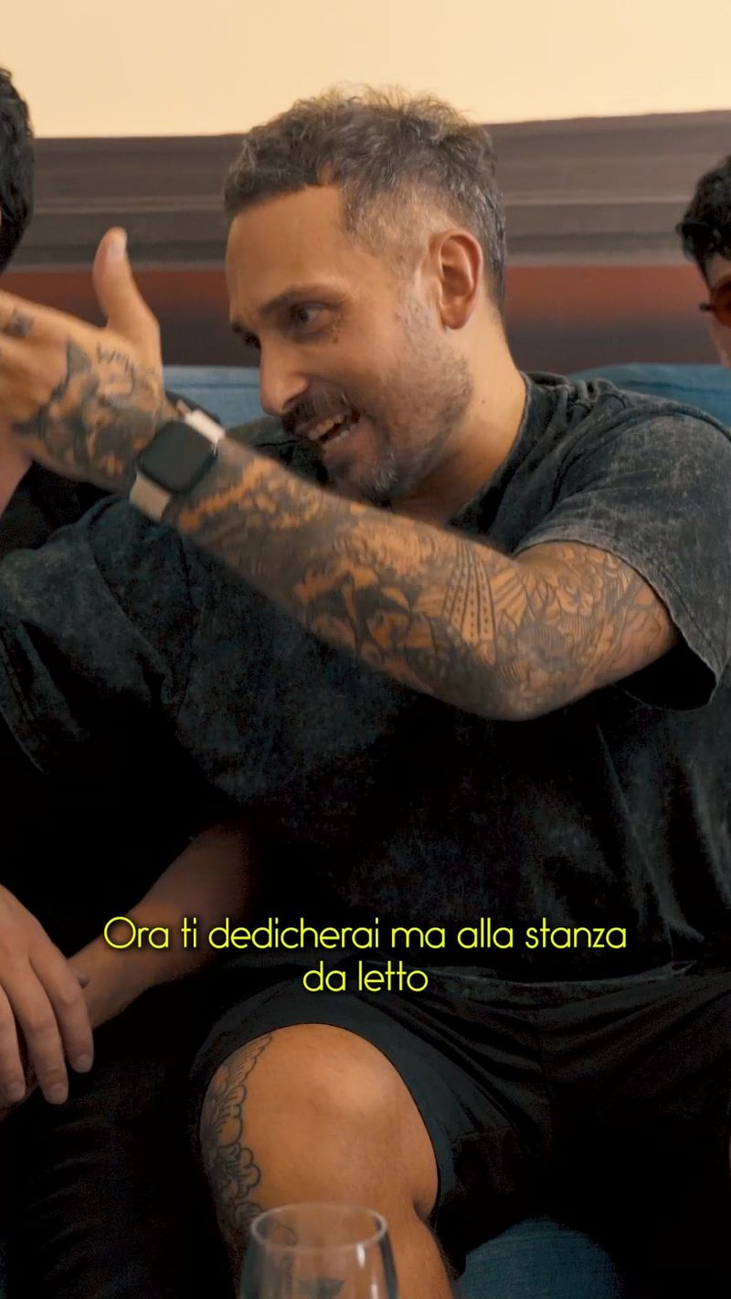 Un uomo seduto parla guardando l'obiettivo, con i sottotitoli in sovrimpressione