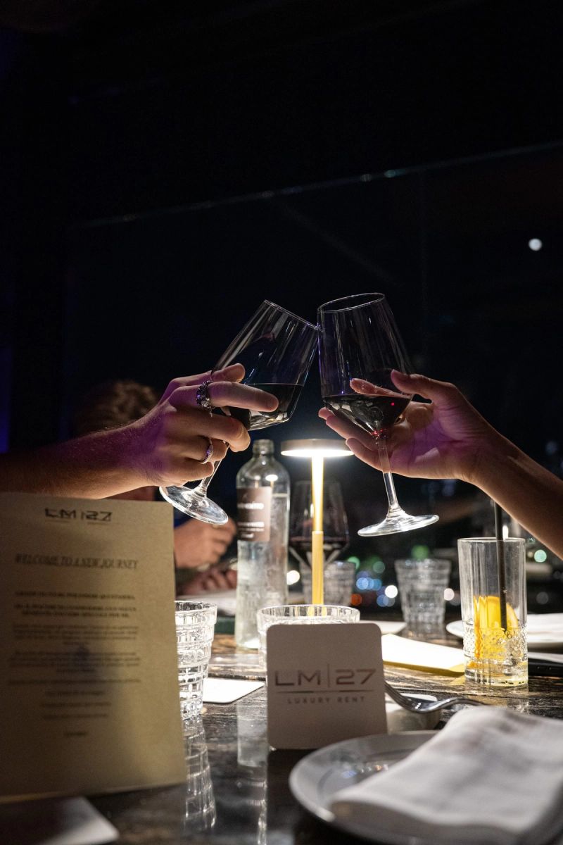 Due persone brindano con i calici sopra a un tavolo di ristorante, di sera