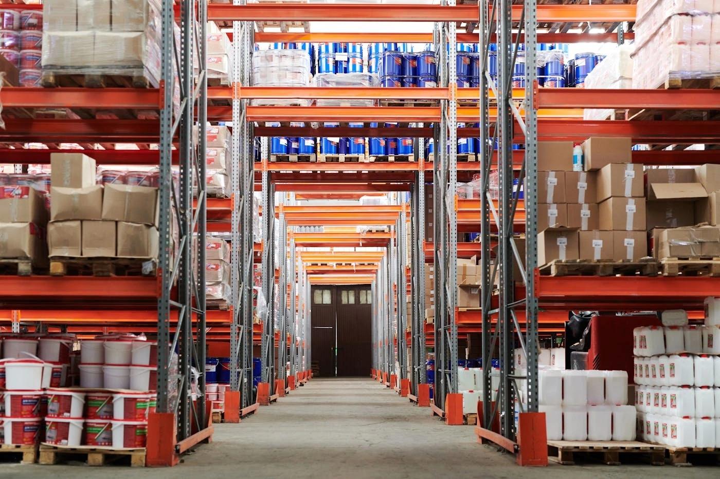 This comundo blog post about real estate industry trends in 2025 has a main image showing the inside of a warehouse. There are no people, but we can see shelves of neatly stacked goods.