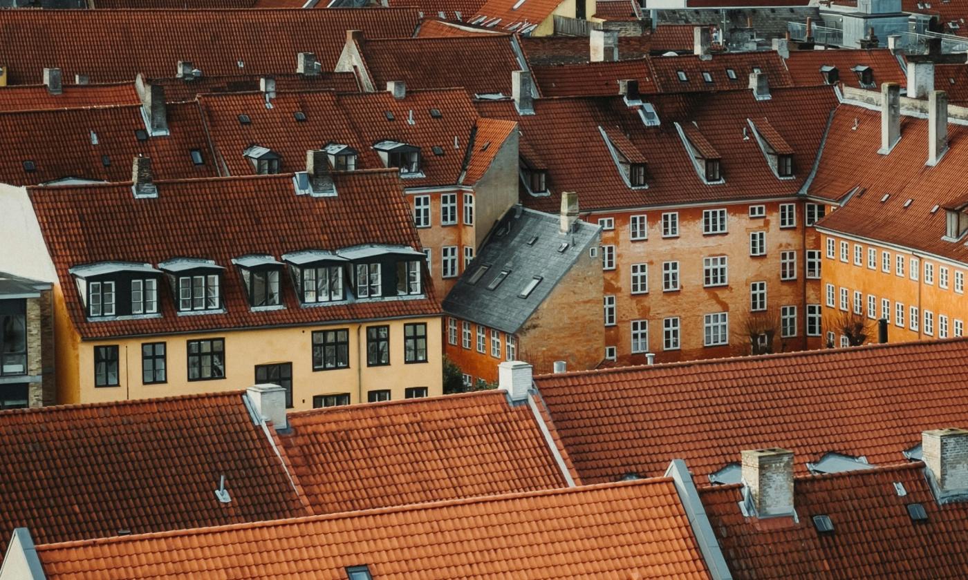 The main image for this comundo blog post about benchmarking the Danish property market is a shot of typical traditional Danish housing, i.e. densely packed together houses with tiled roofs, yellow exteriors and small windows.