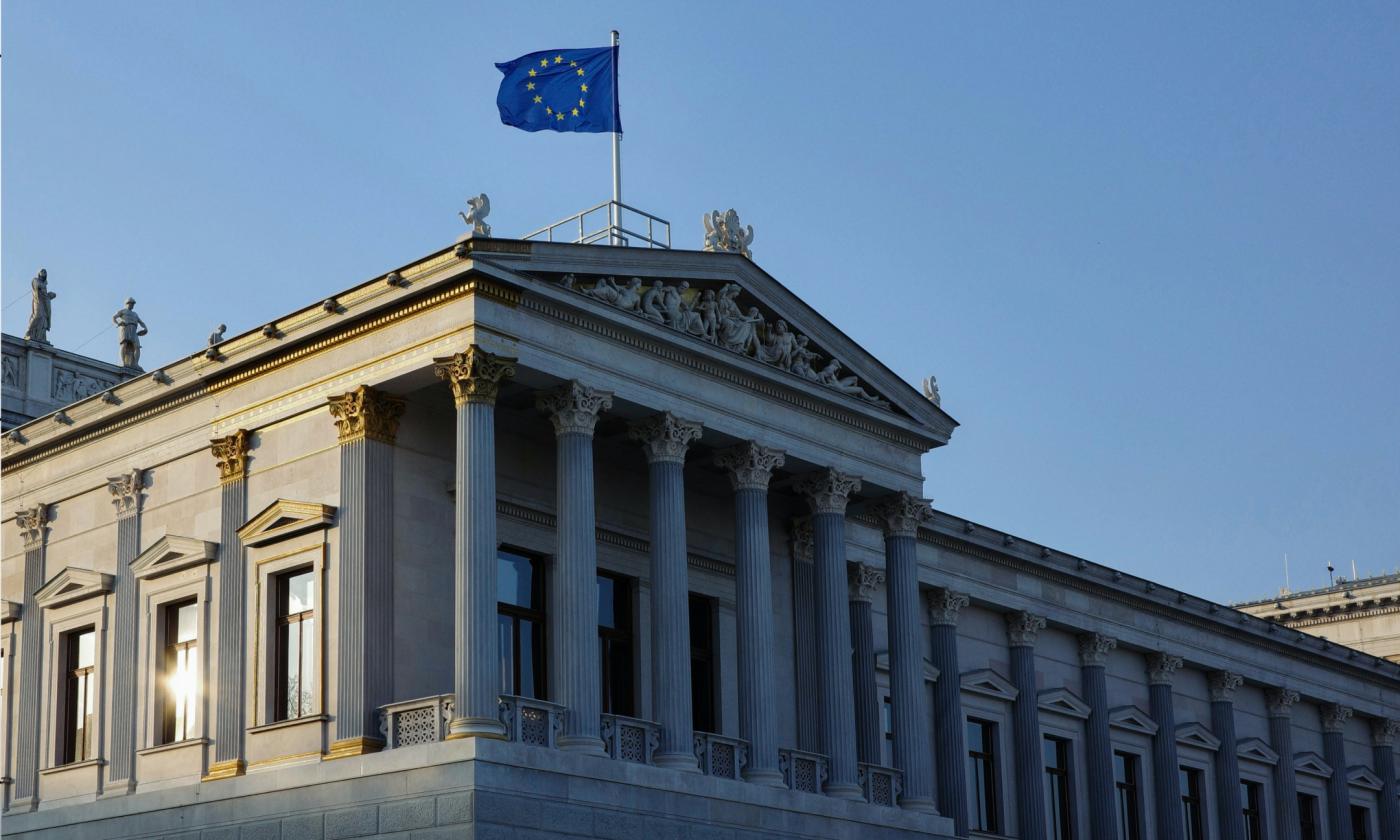 This comundo blog post about the EU Omnibus proposal has a header photo of the Austrian Parliament building with an EU flag being flown on the flag pole.