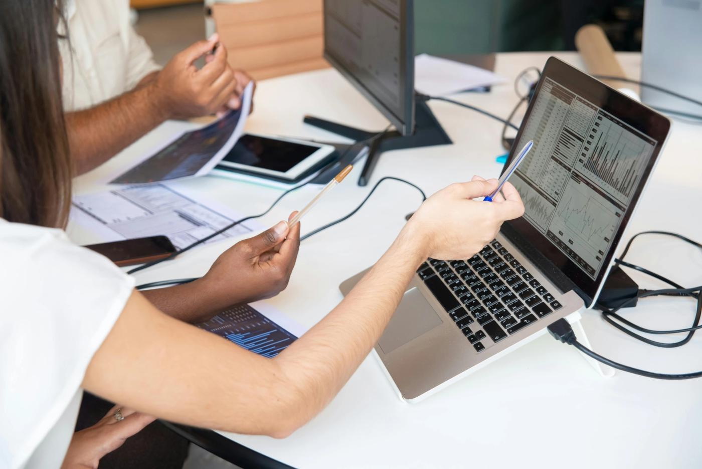 The main image for this comundo blog post about AI and machine learning in carbon accounting is a photo of two people at at desk working on their laptops.