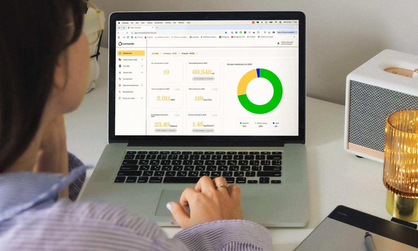 The main image for this comundo blog post about creating a net-zero strategy is an over-the-shoulder shot of the comundo platform. We can see a laptop on a man's lap, and his crossed legs just behind the screen
