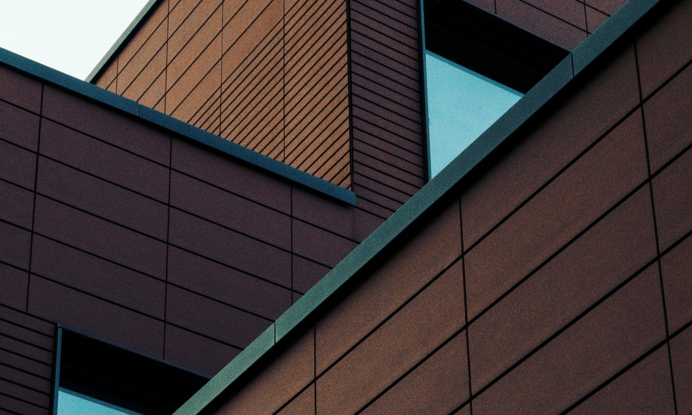 An extreme close-up photo of a building showing concrete panels and a window corner