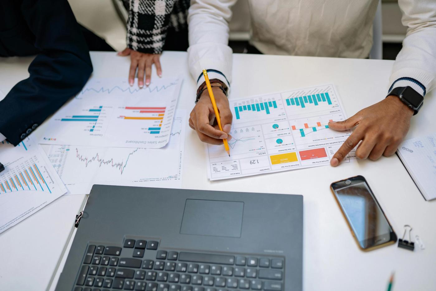 The primary image for this comundo blog post about energy data and real estate investment shows a team of people at a desk working on calculations