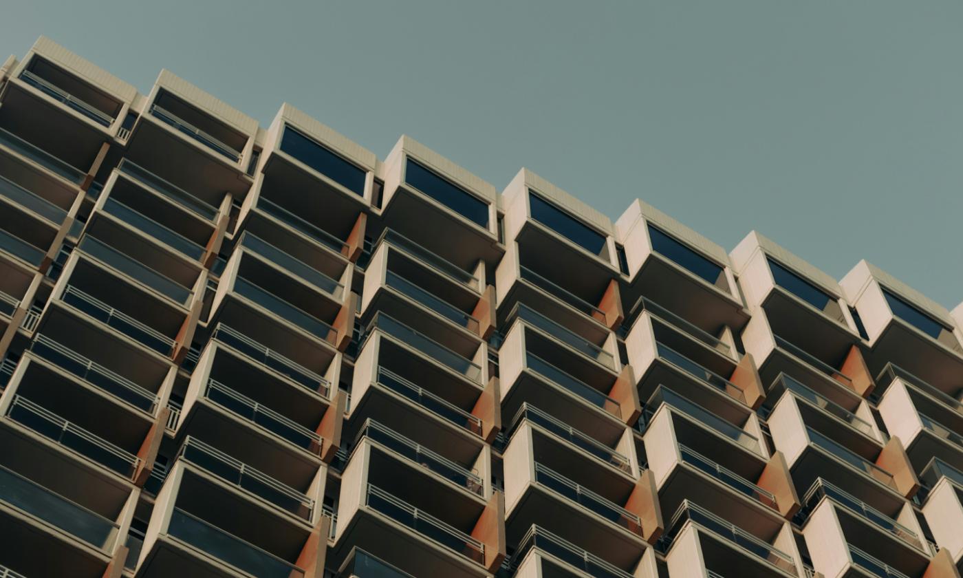 A photo taken from a low perspective of a block of flats. It's pleasingly symmetrical.