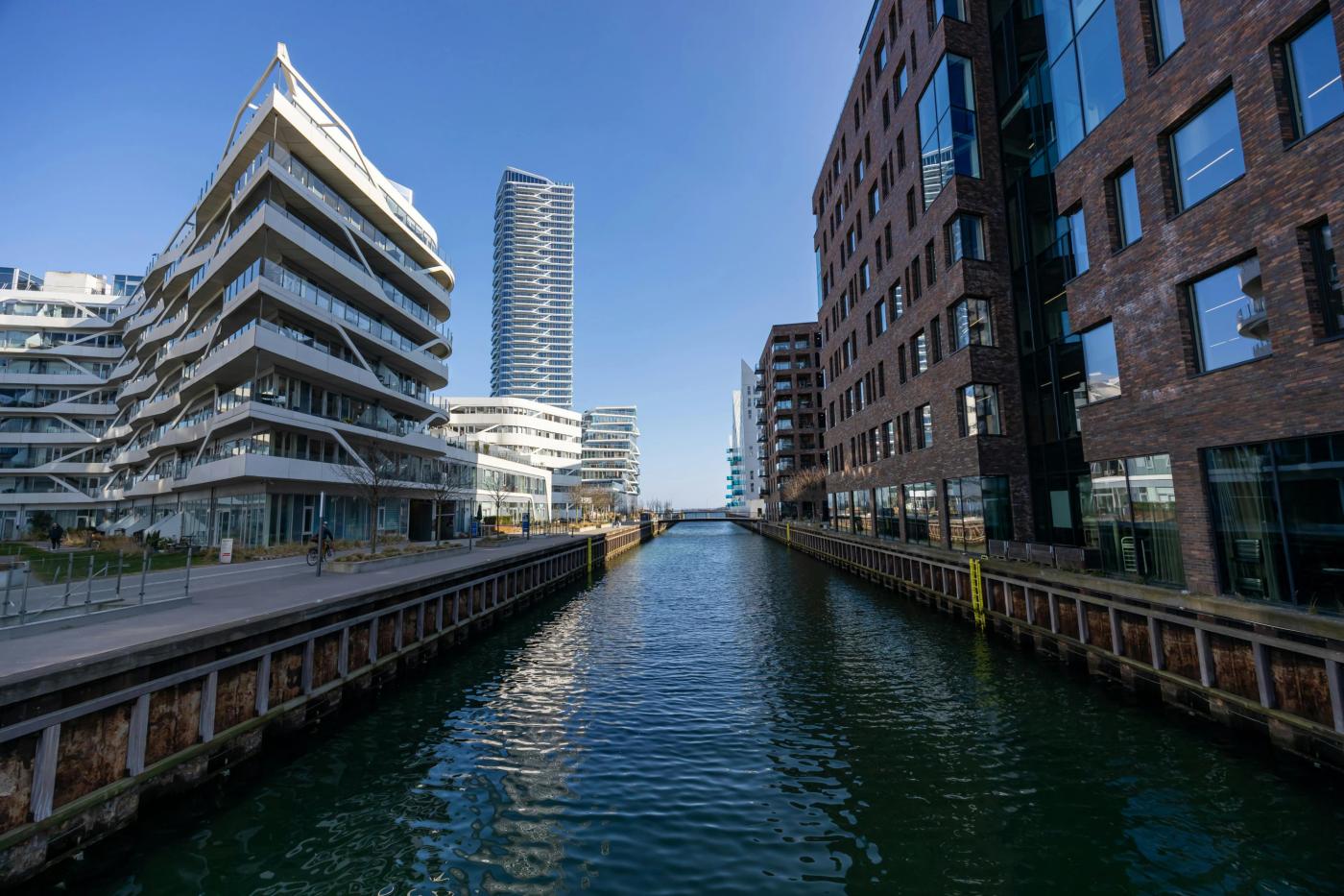 This comundo blog post's header image about the revised EPBD, is a photo showing modern architecture along a canal in the Aarhus Ø district of Aarhus, Denmark. We can see the canal beheath, and buildings rising up either side.